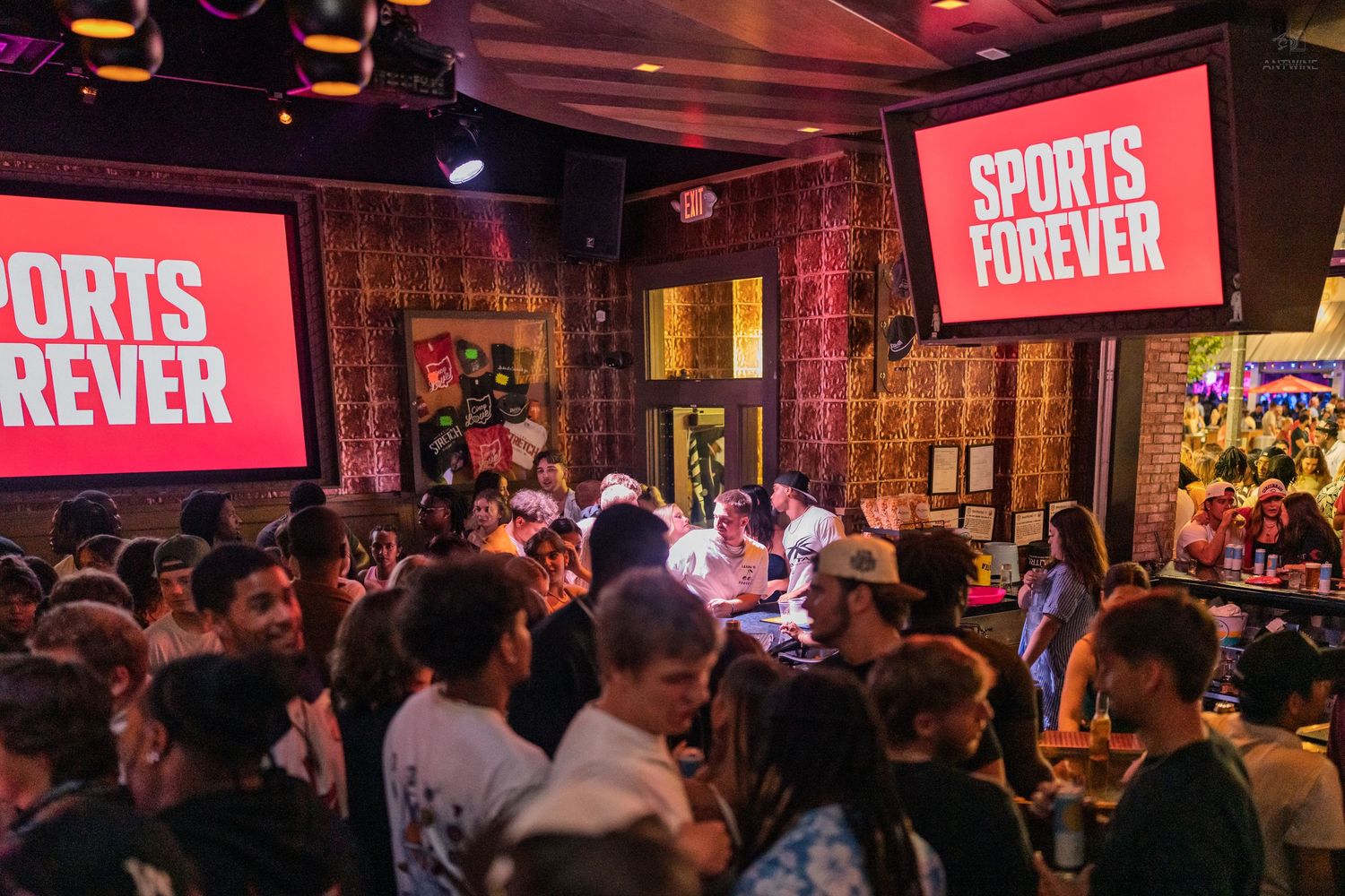 Lively Sports Forever bar event with large screens and an enthusiastic crowd of attendees.