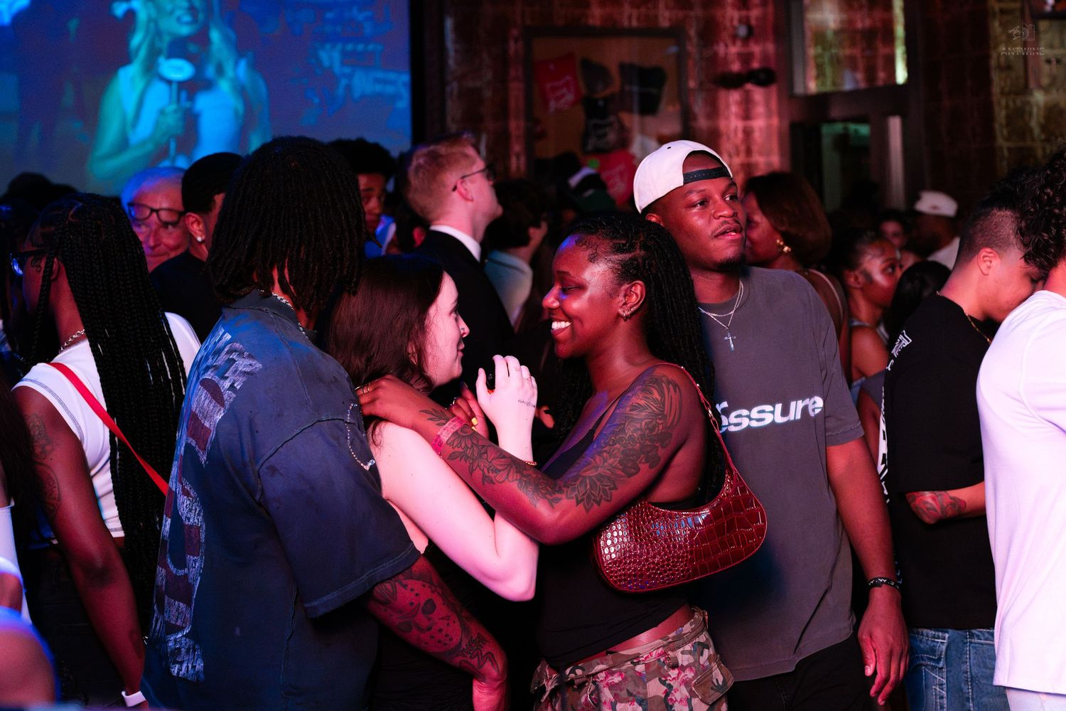 People socializing and dancing at a lively indoor music venue event.