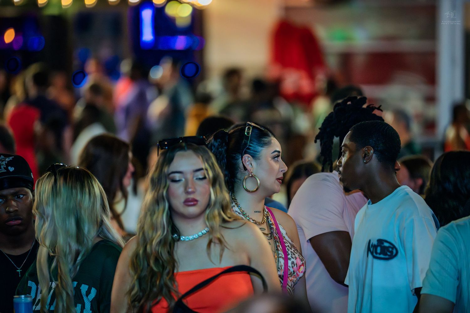 Crowd of young people socializing at an outdoor nighttime party event.