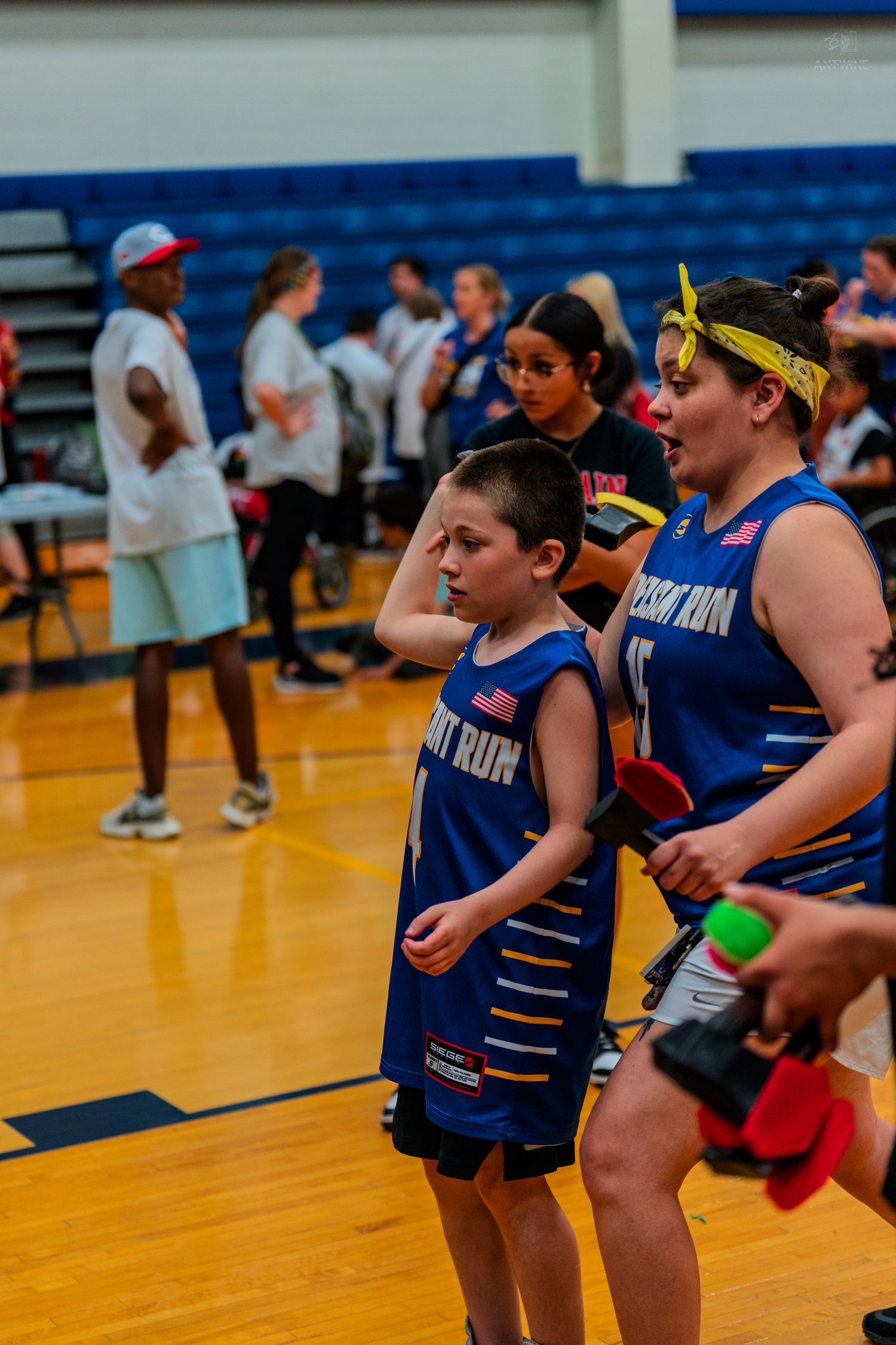Young basketball players in blue uniforms on an indoor court during a youth league game.