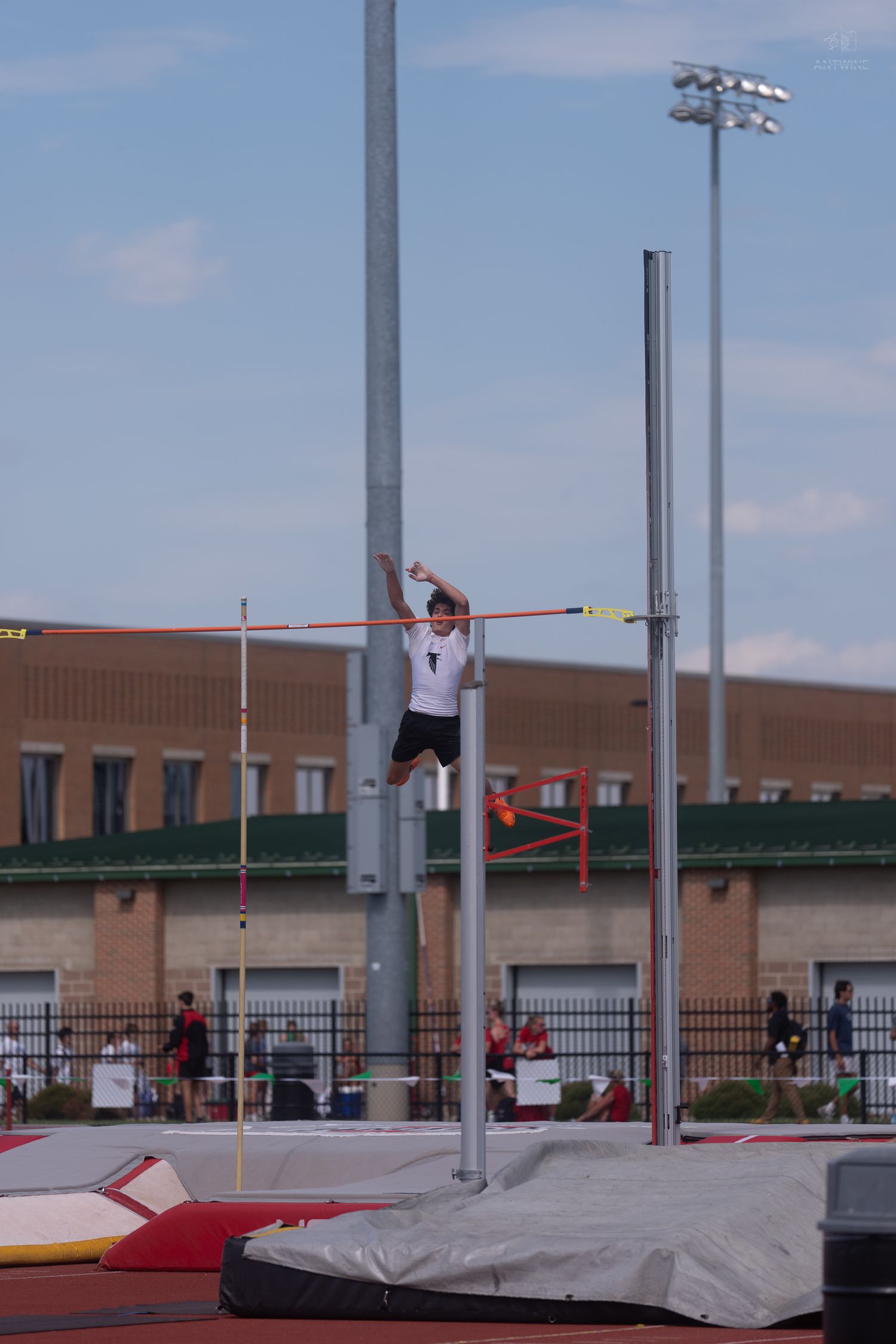 Athlete rises above the crossbar during a pole vault attempt at an Ohio State track meet.