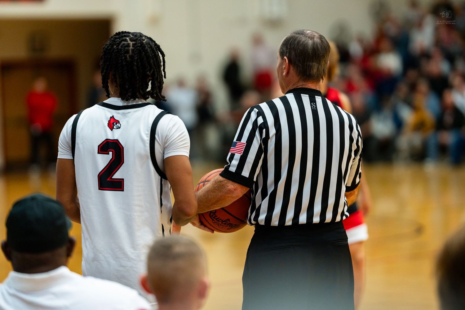 Basketball player number 2 receives ball from referee during high school game.