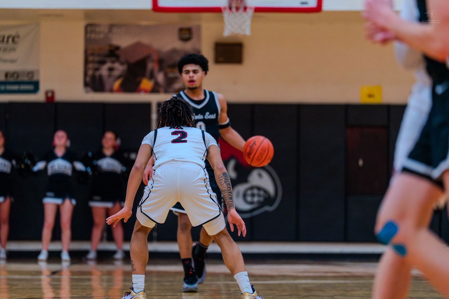 Lakota East #0 handles ball against defender #2 in high school game.