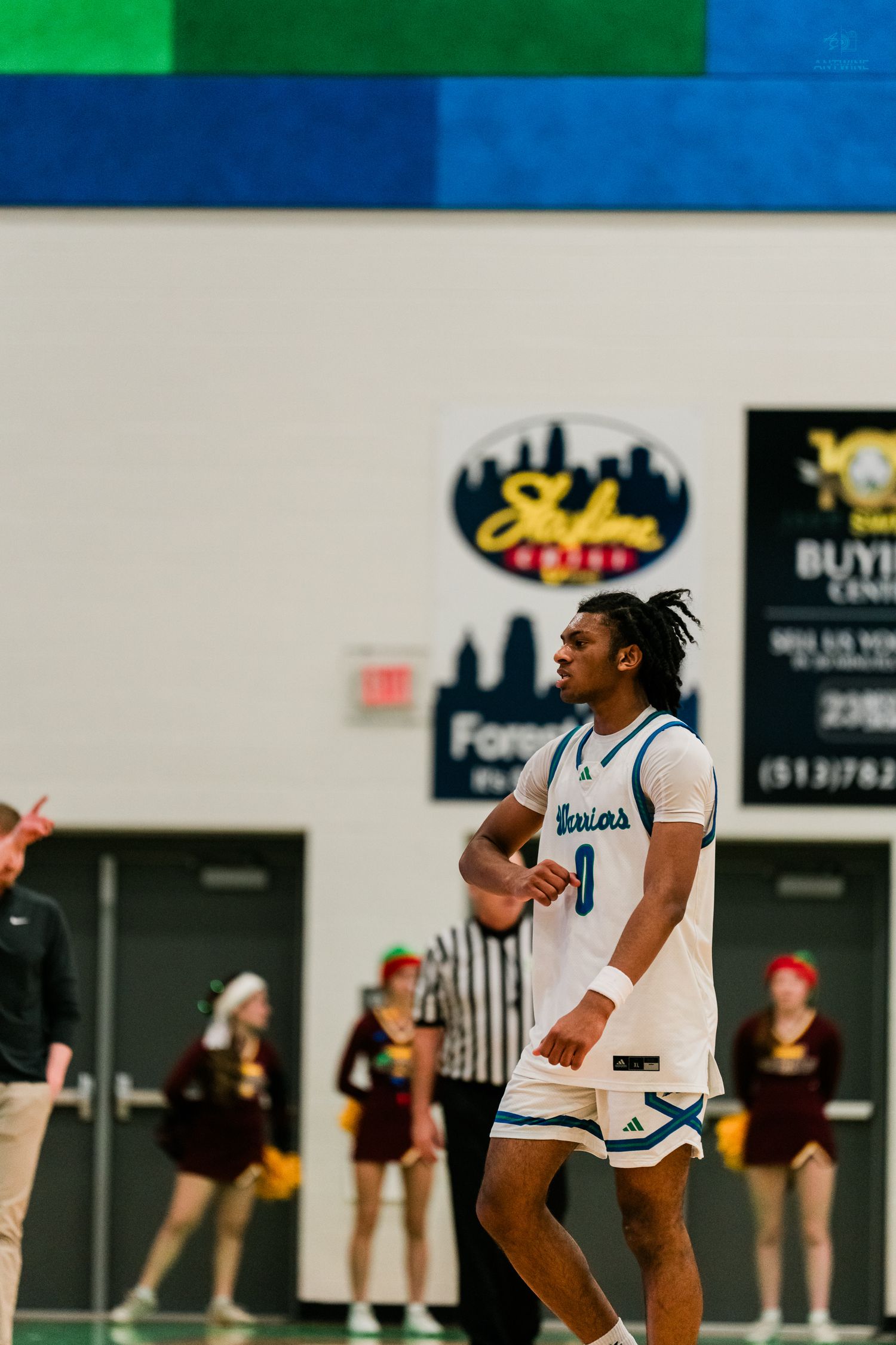 Xavier Warriors basketball player number 0 walks on the court during a high school game.