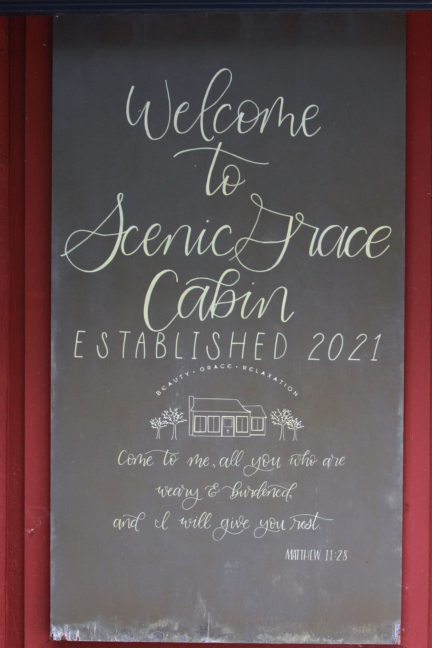Welcome sign for Scenic Grace Cabin established 2021 with a Bible verse from Matthew 11:28.