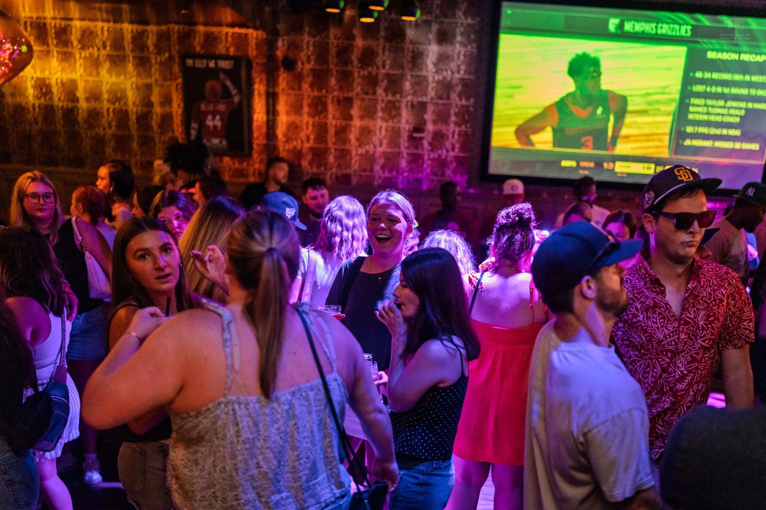 Crowded nightclub dance floor with purple lighting and large screen displaying Memphis Circuit event.
