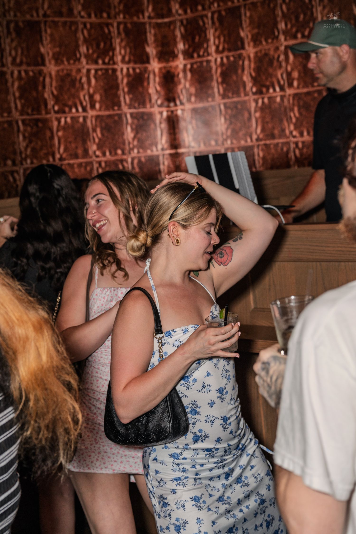 Two women dancing and laughing at an indoor party or nightclub event.