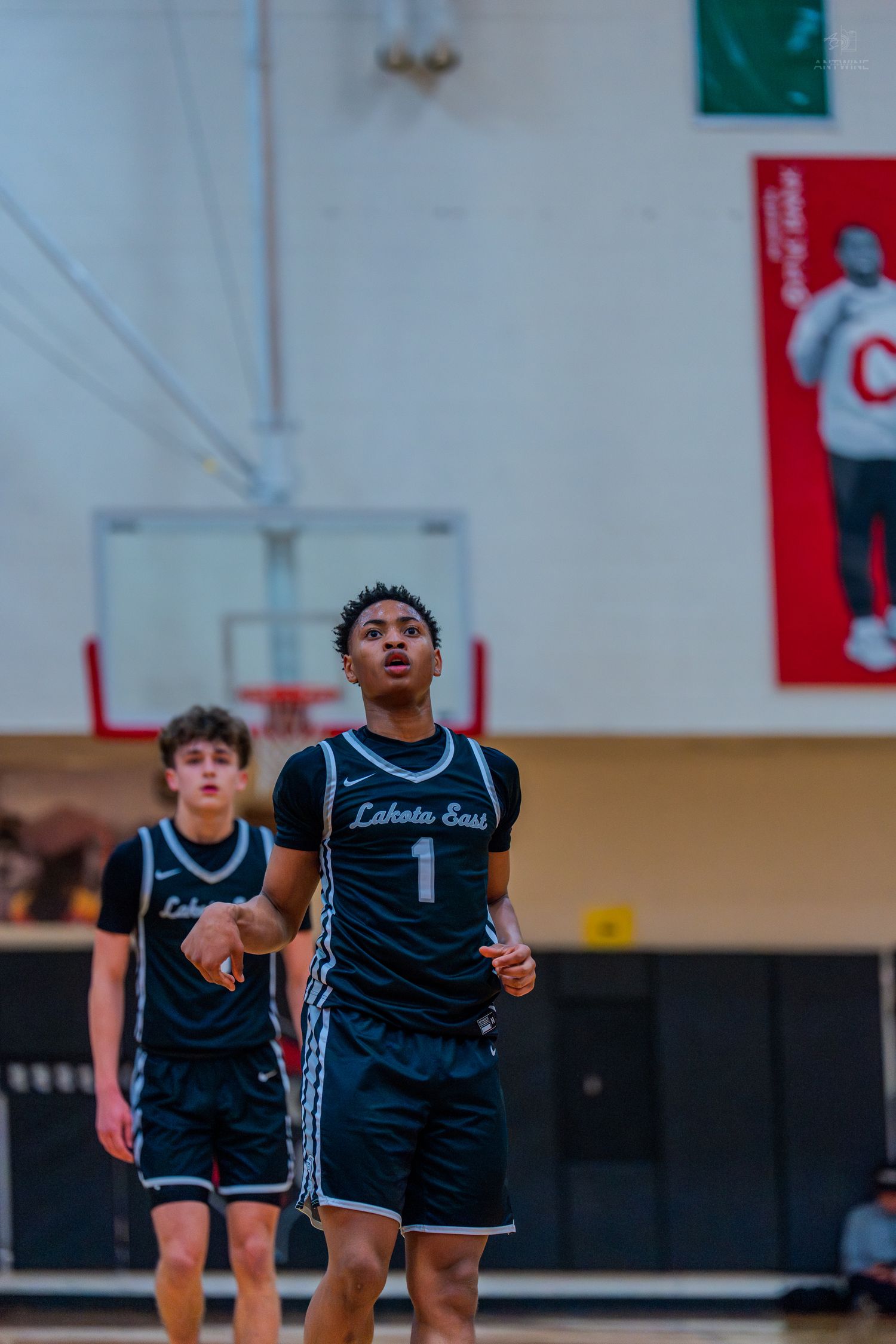Lakota East basketball players #1 and #3 walk on court during a high school game.