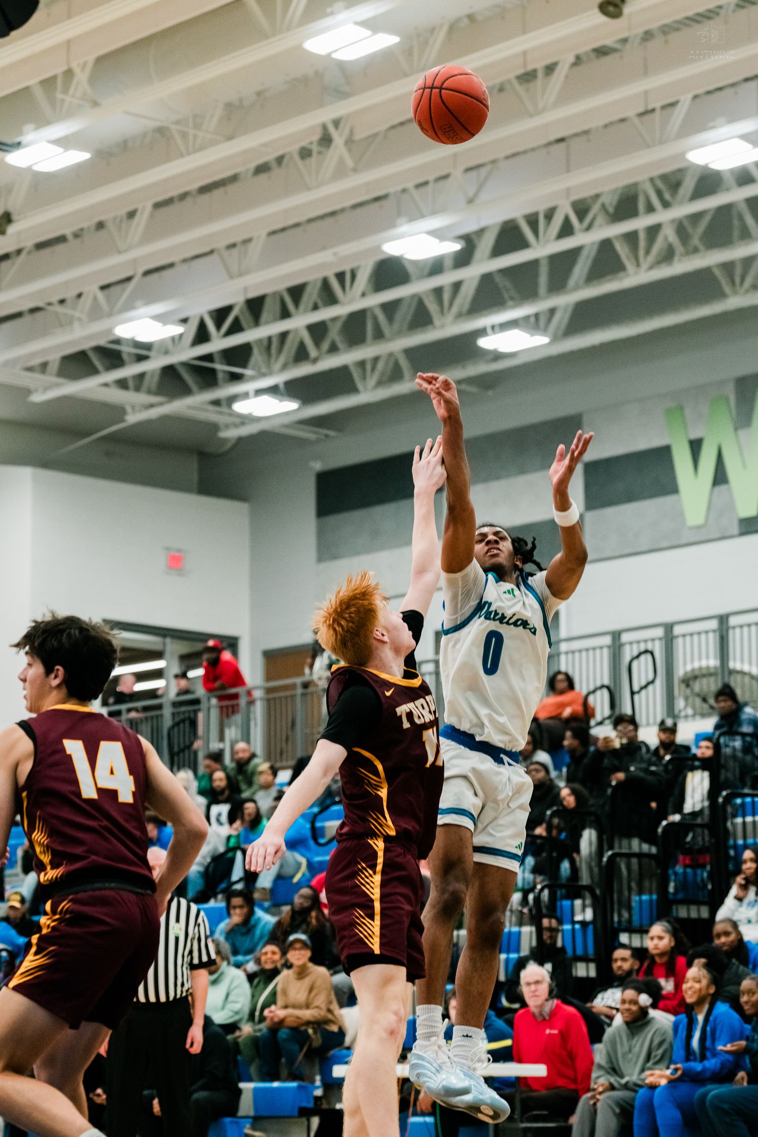 Warriors player #0 shoots a jump shot over Turpin defenders during a high school basketball game.