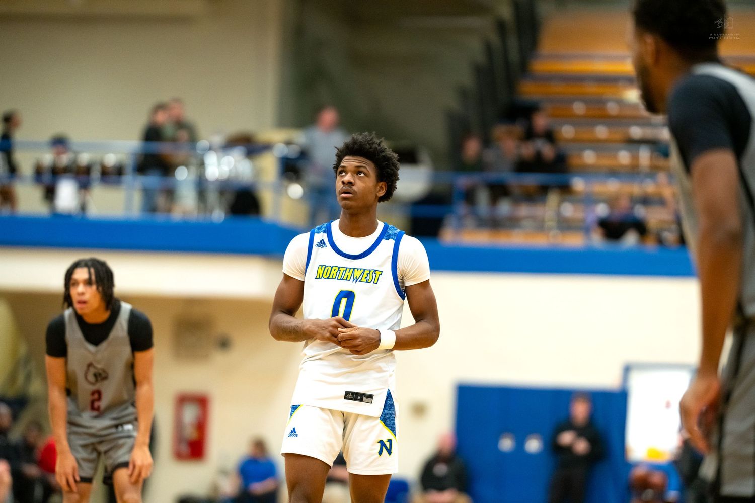 Player number 0 in blue Northwest basketball uniform stands focused during a game.