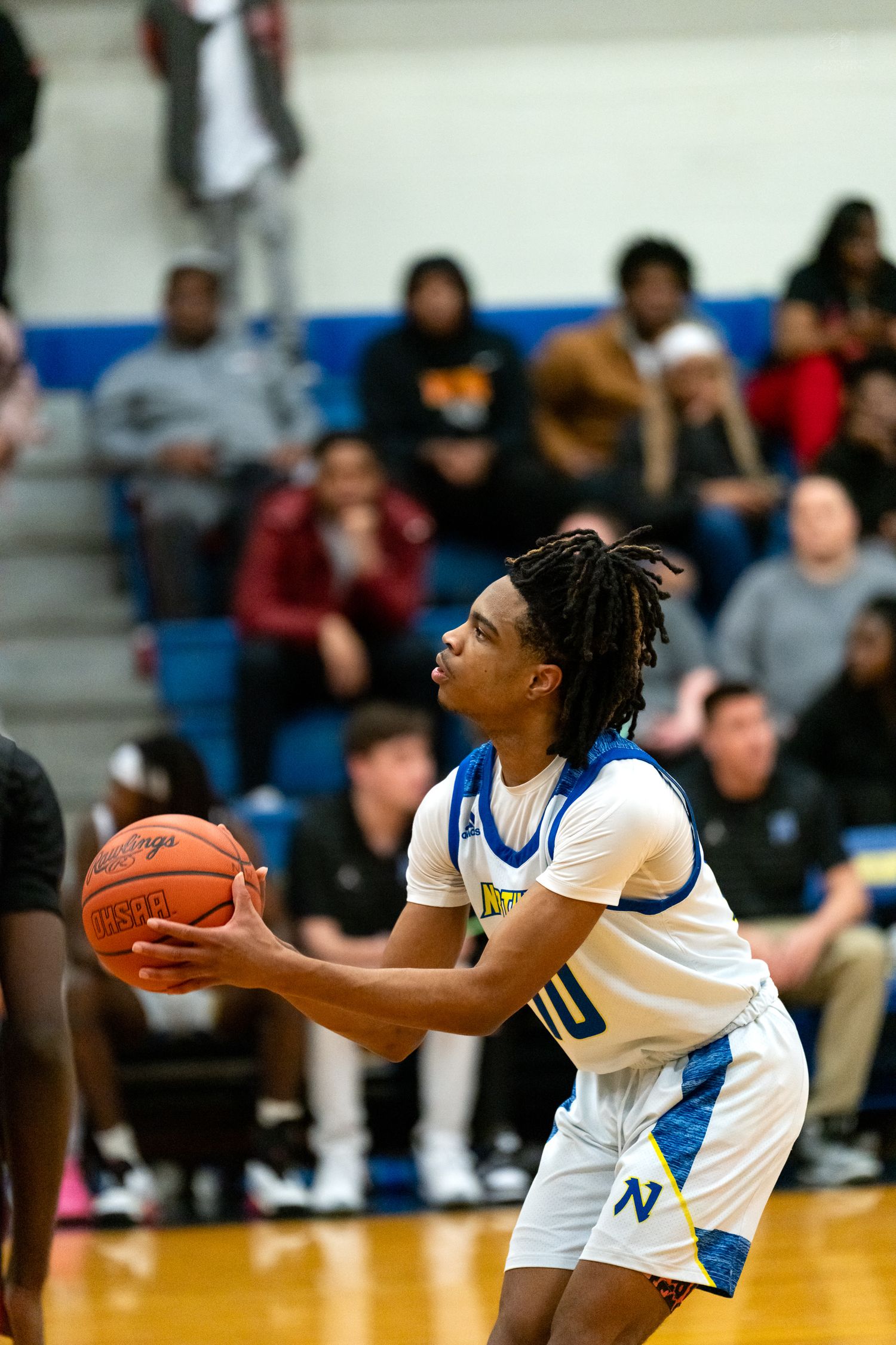 Northwest Knights player number 10 focuses on basket while preparing to shoot a free throw in a high school game.