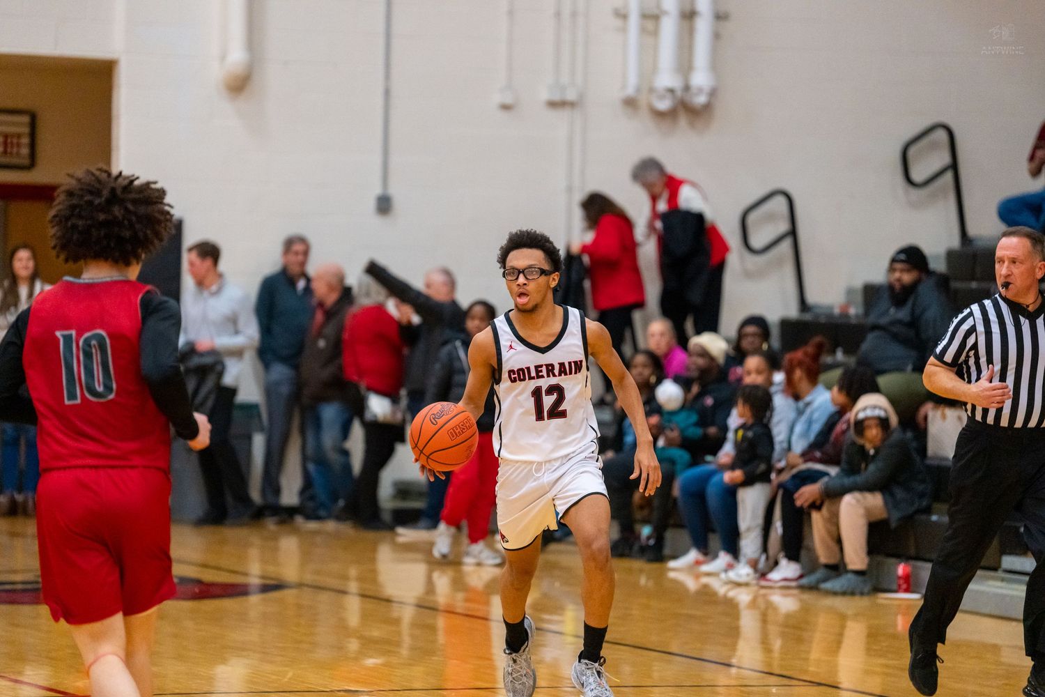 Colerain player number 12 dribbles the ball while being guarded during a high school basketball game.