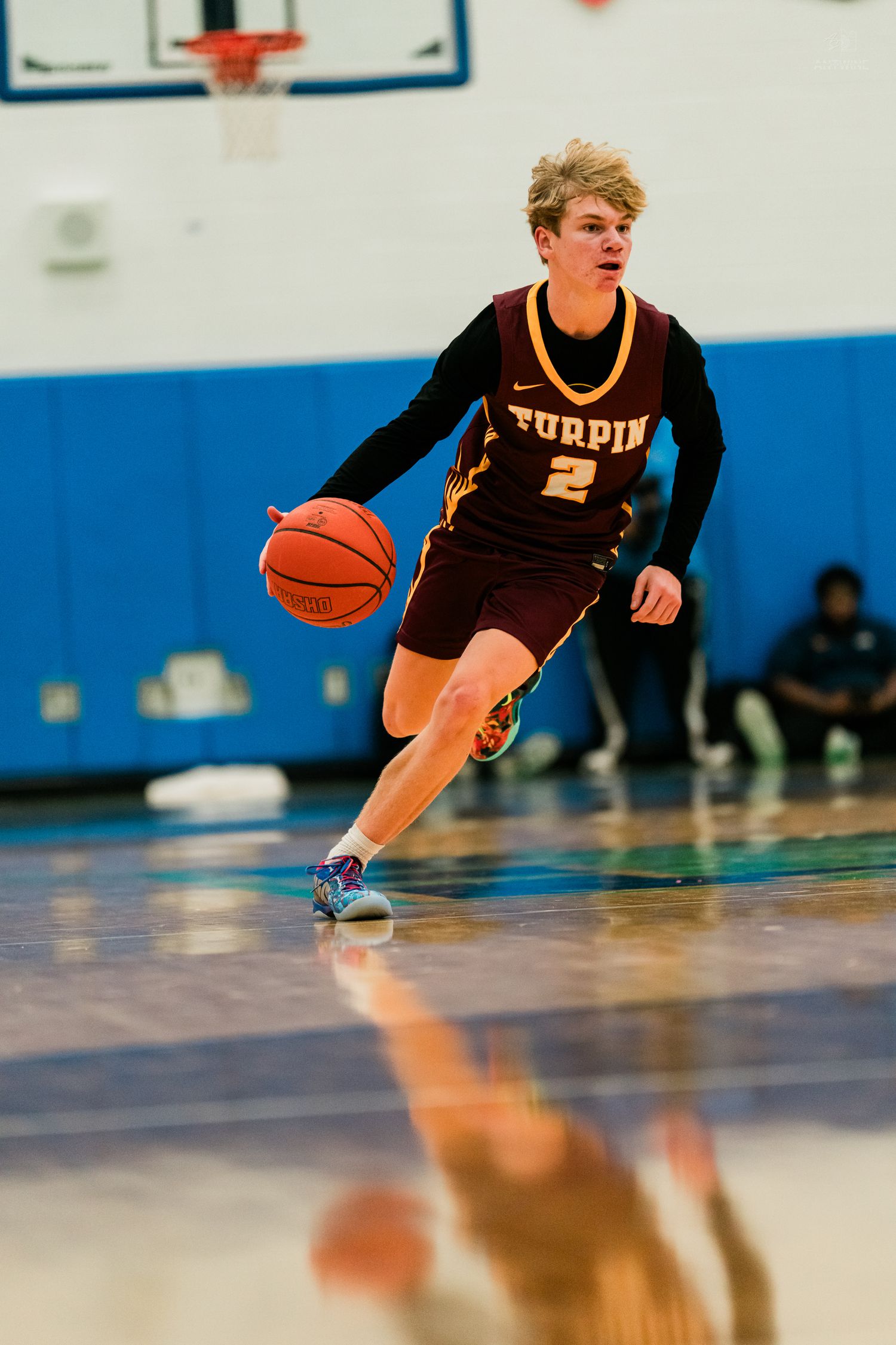 Turpin high school basketball player #2 dribbles ball upcourt during competitive varsity basketball game.