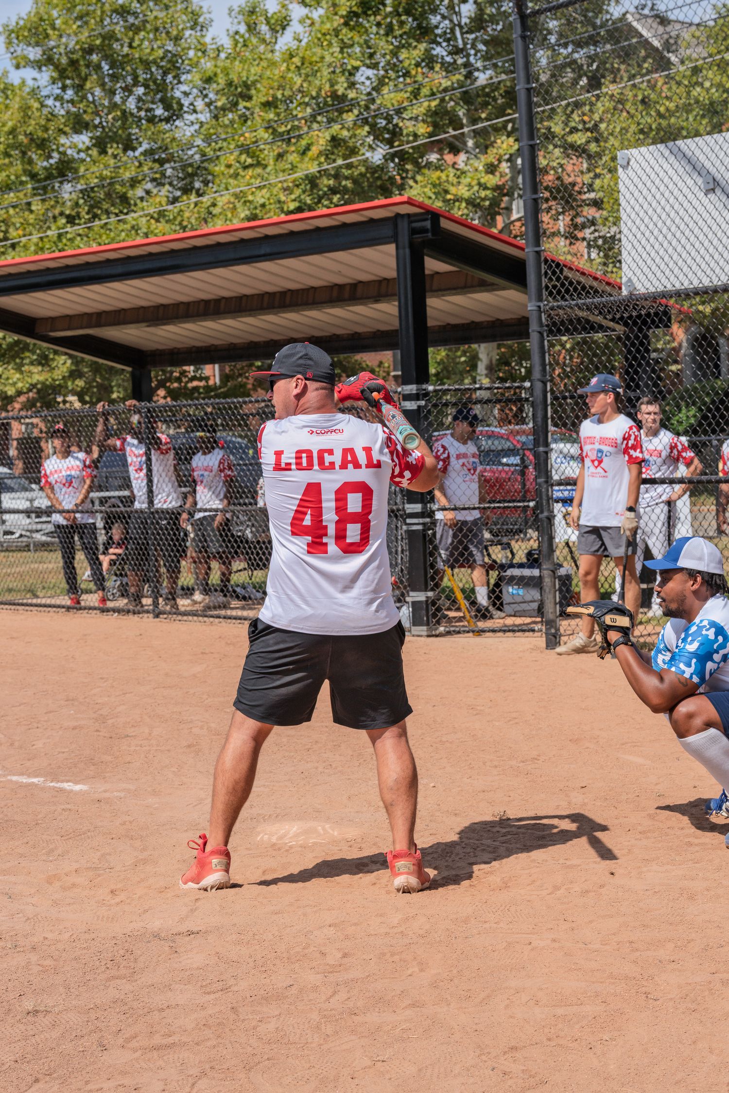 Softball player wearing Local 48 jersey number batting at home plate during an outdoor game.