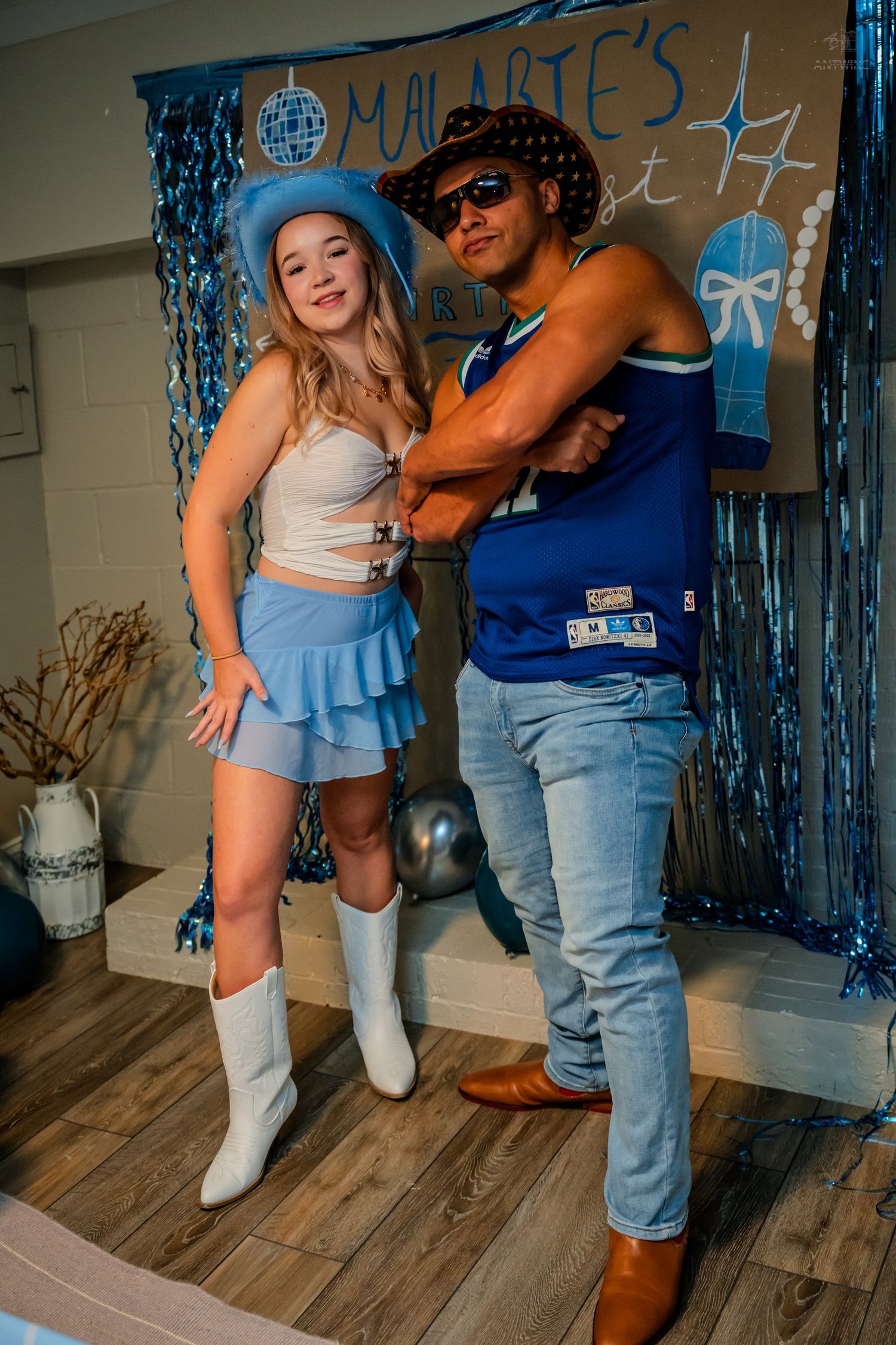Two friends pose playfully at Malarie's 21st birthday party with blue streamers and star decorations.
