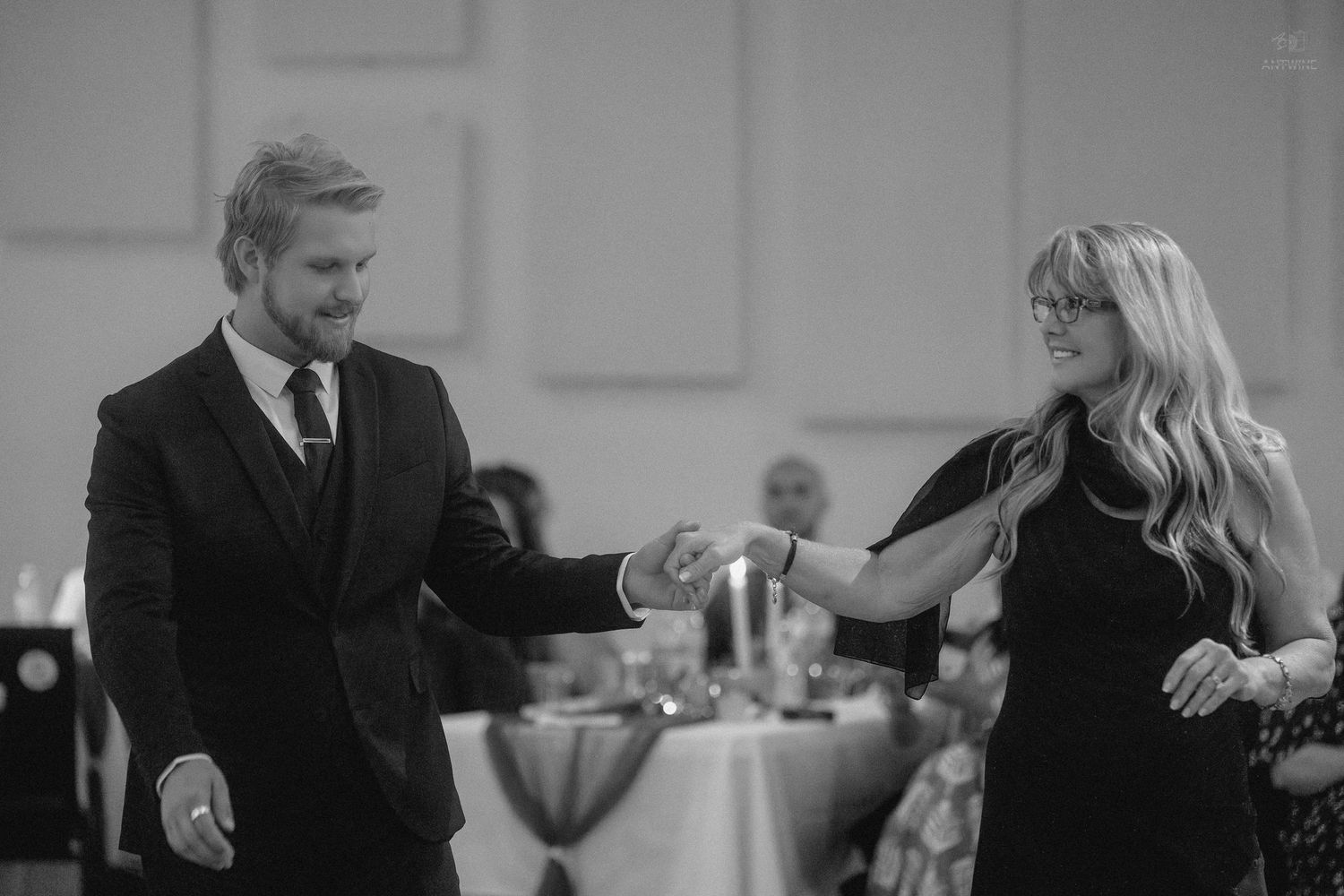 Couple dancing elegantly in black and white photo at a formal wedding reception event.