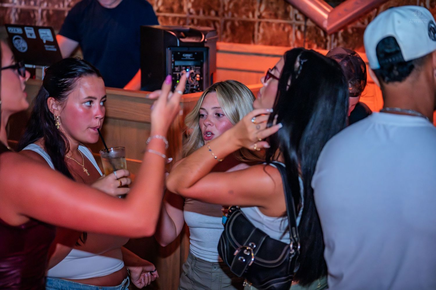 Group of young women taking photos and having fun together at a lively nightclub event.