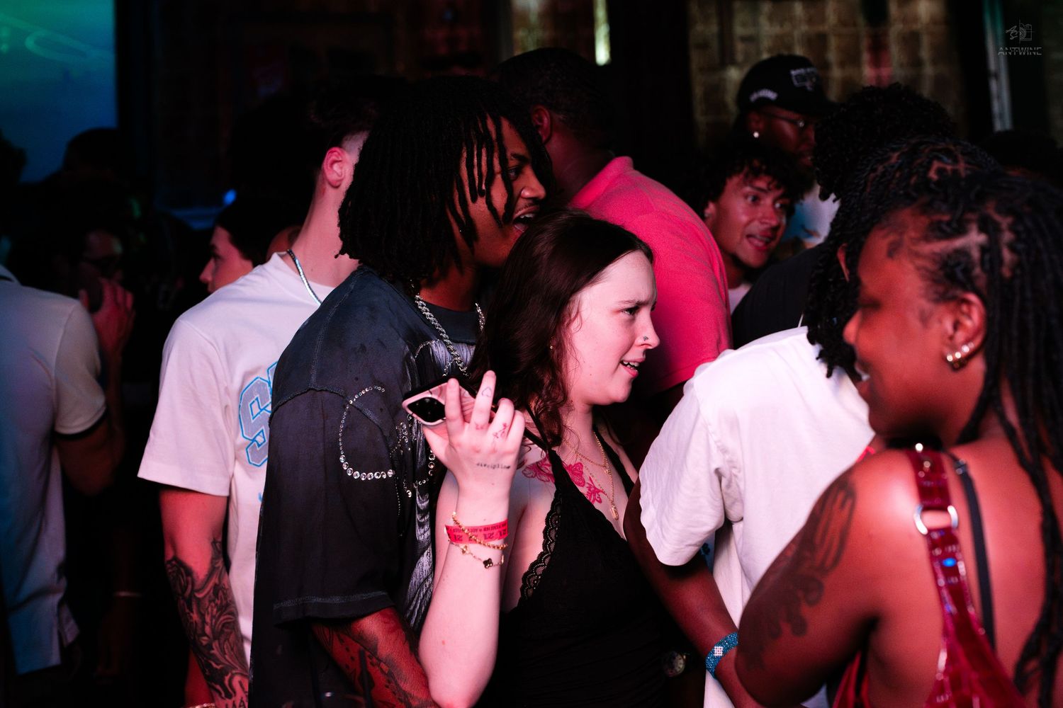 Young woman smiling and enjoying herself at a crowded nightclub party.