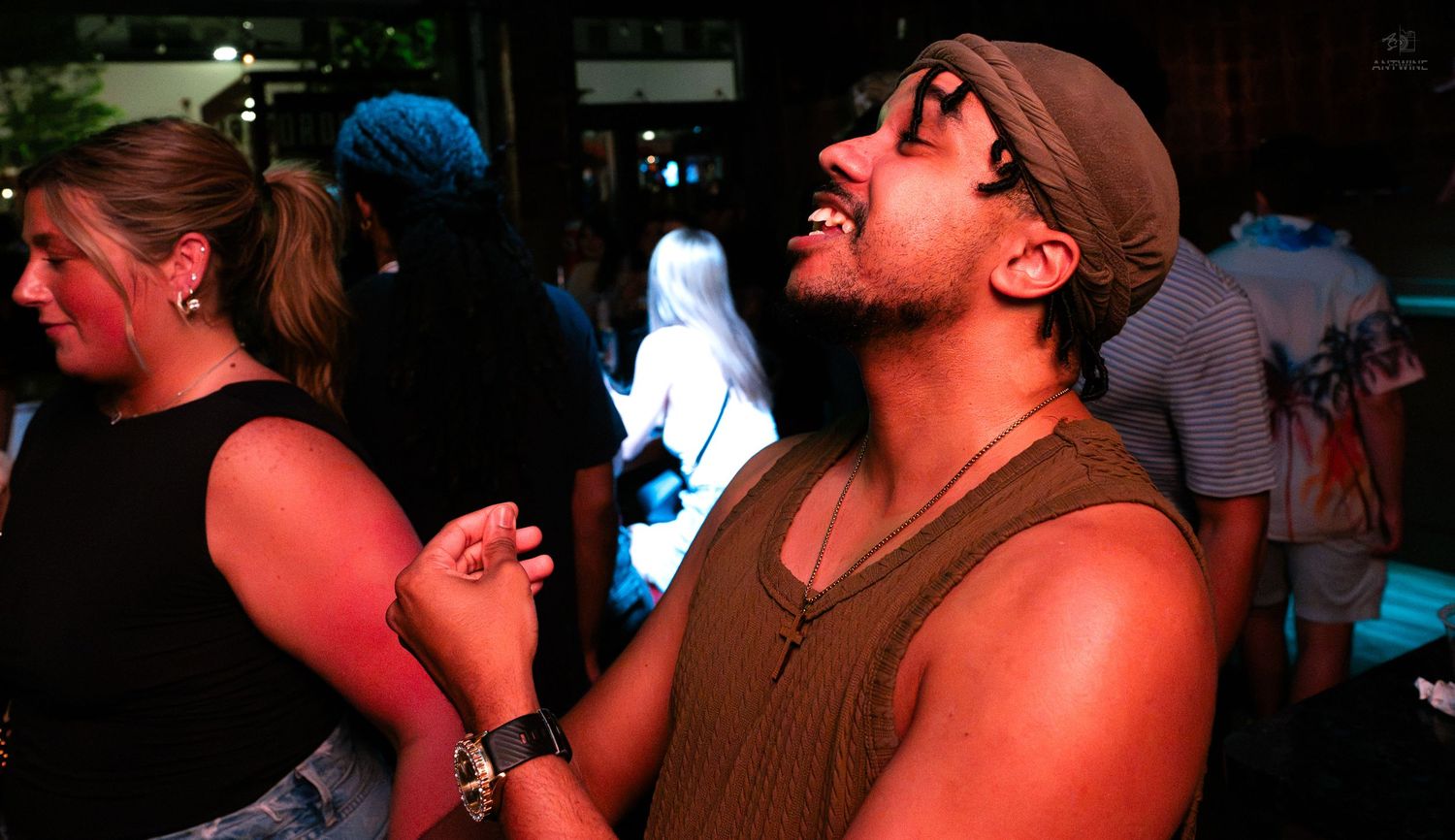 Man laughing joyfully while dancing at a lively nightclub event.