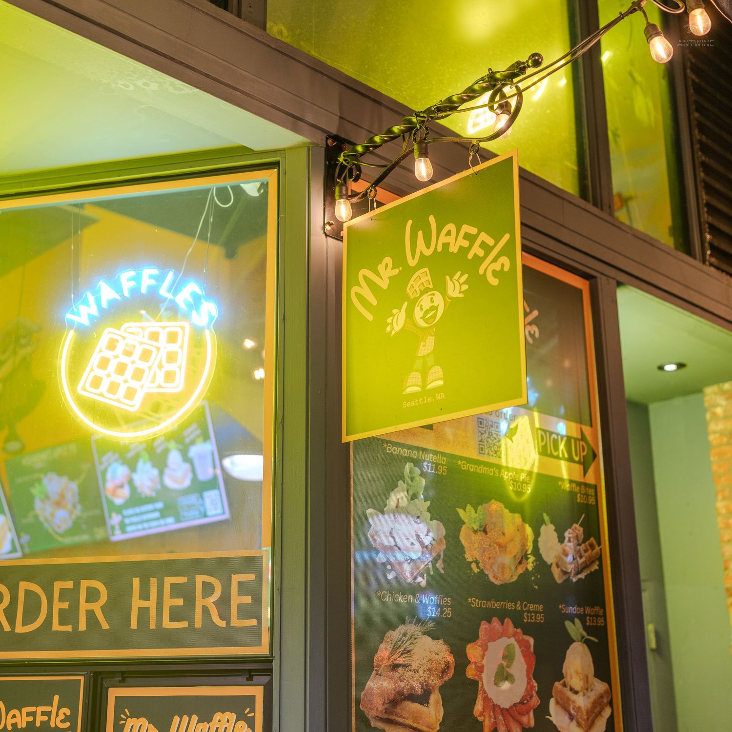 Mr. Waffle restaurant storefront with neon signs and green exterior lighting at night.
