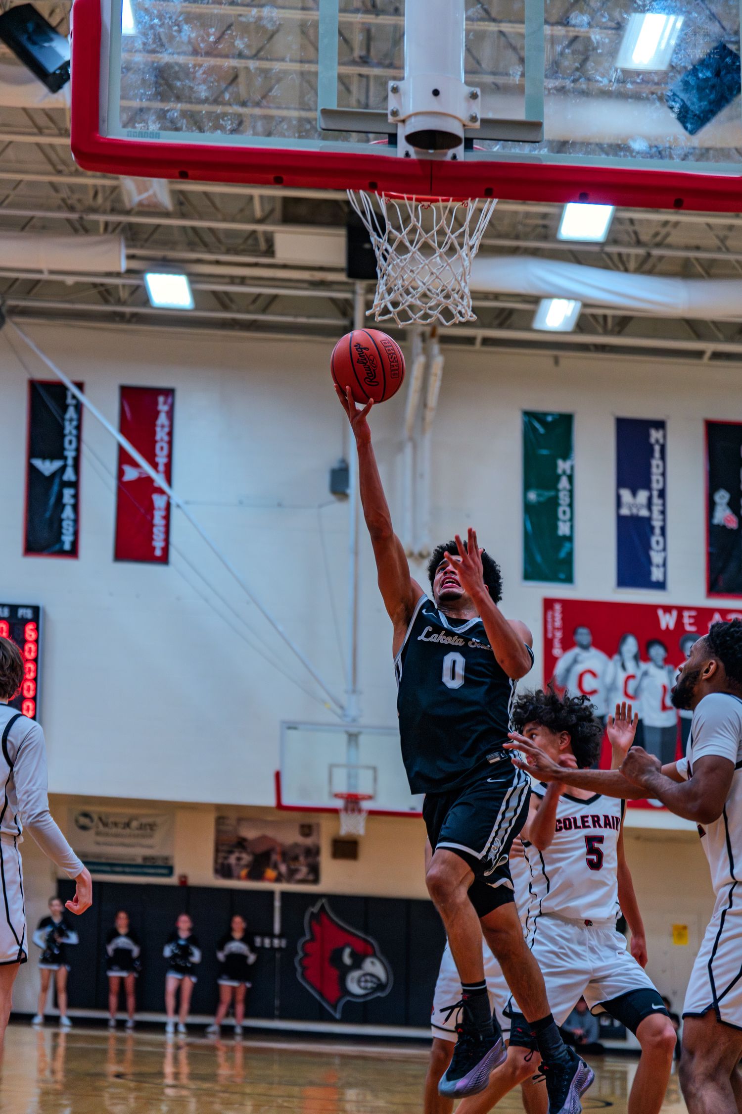 Lakota East #0 goes up for layup in high school basketball game.