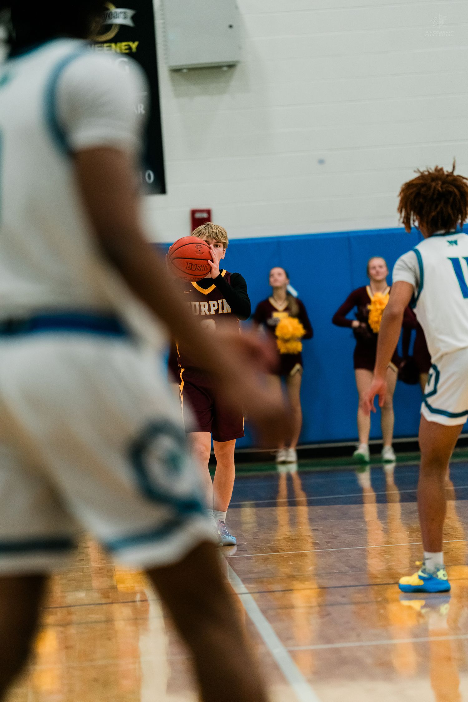 Turpin High School basketball player dribbles during a game against a team in white uniforms on an indoor court.