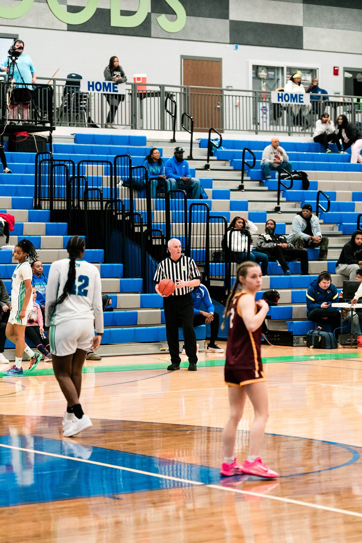 Referee holds the basketball at midcourt during a Winton Woods girls basketball game against Turpin.