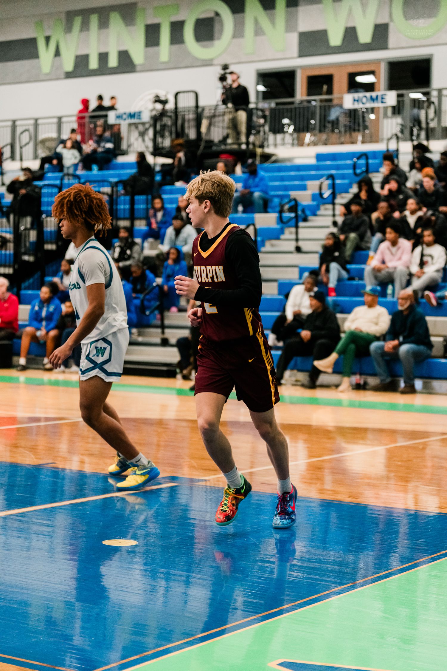 Turpin High School basketball player runs down the court at Winton Woods gym during a competitive game.