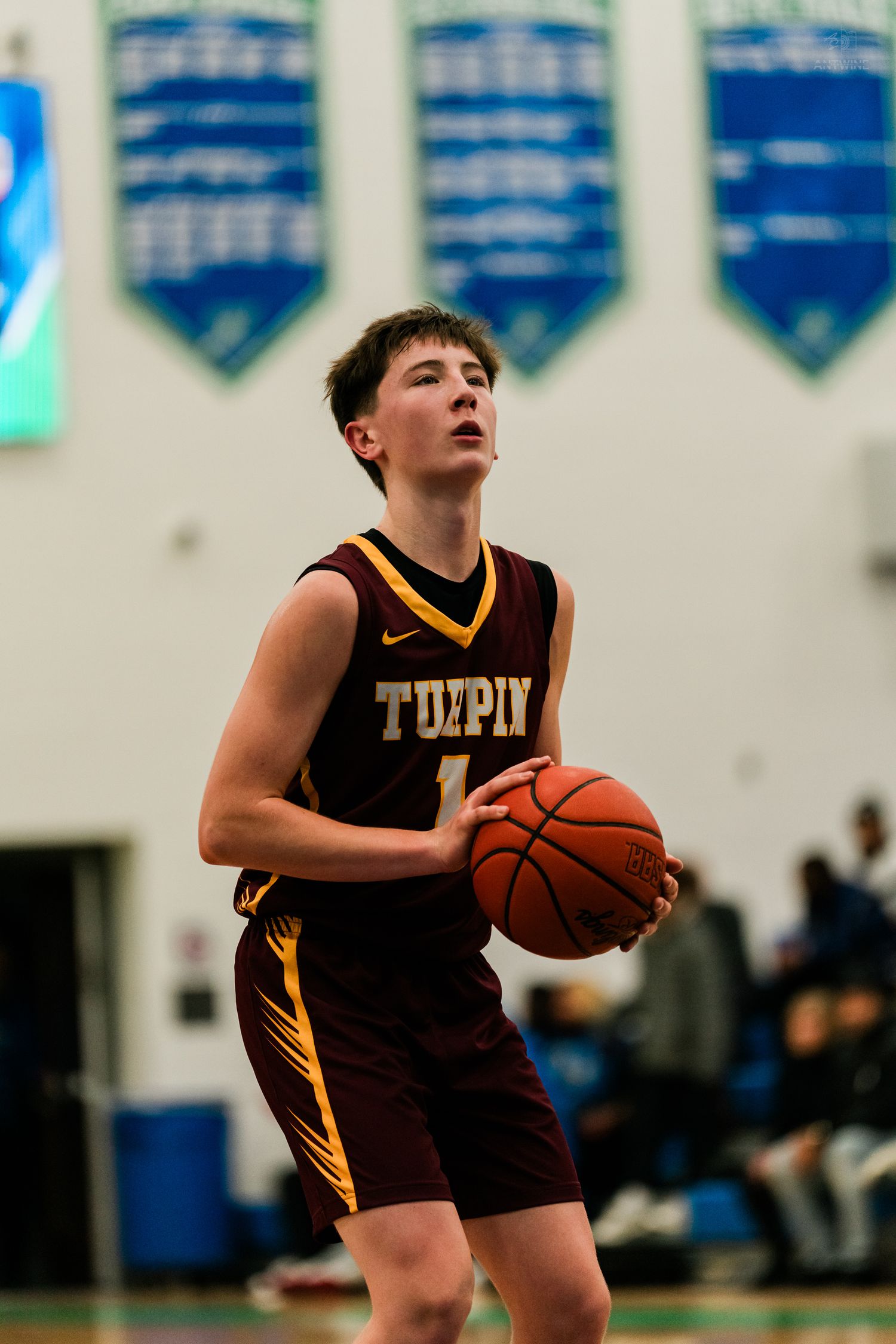 Turpin High School basketball player number 1 prepares for a free throw in a gymnasium.