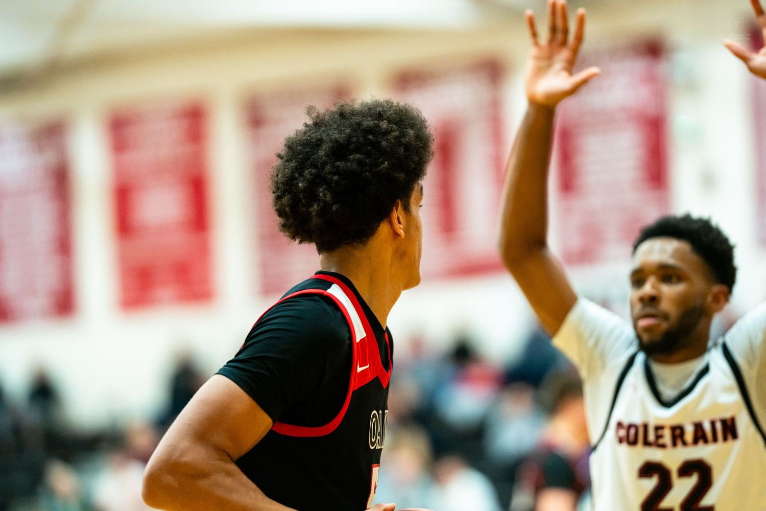 Colerain basketball player #22 guards opponent during intense high school basketball game.