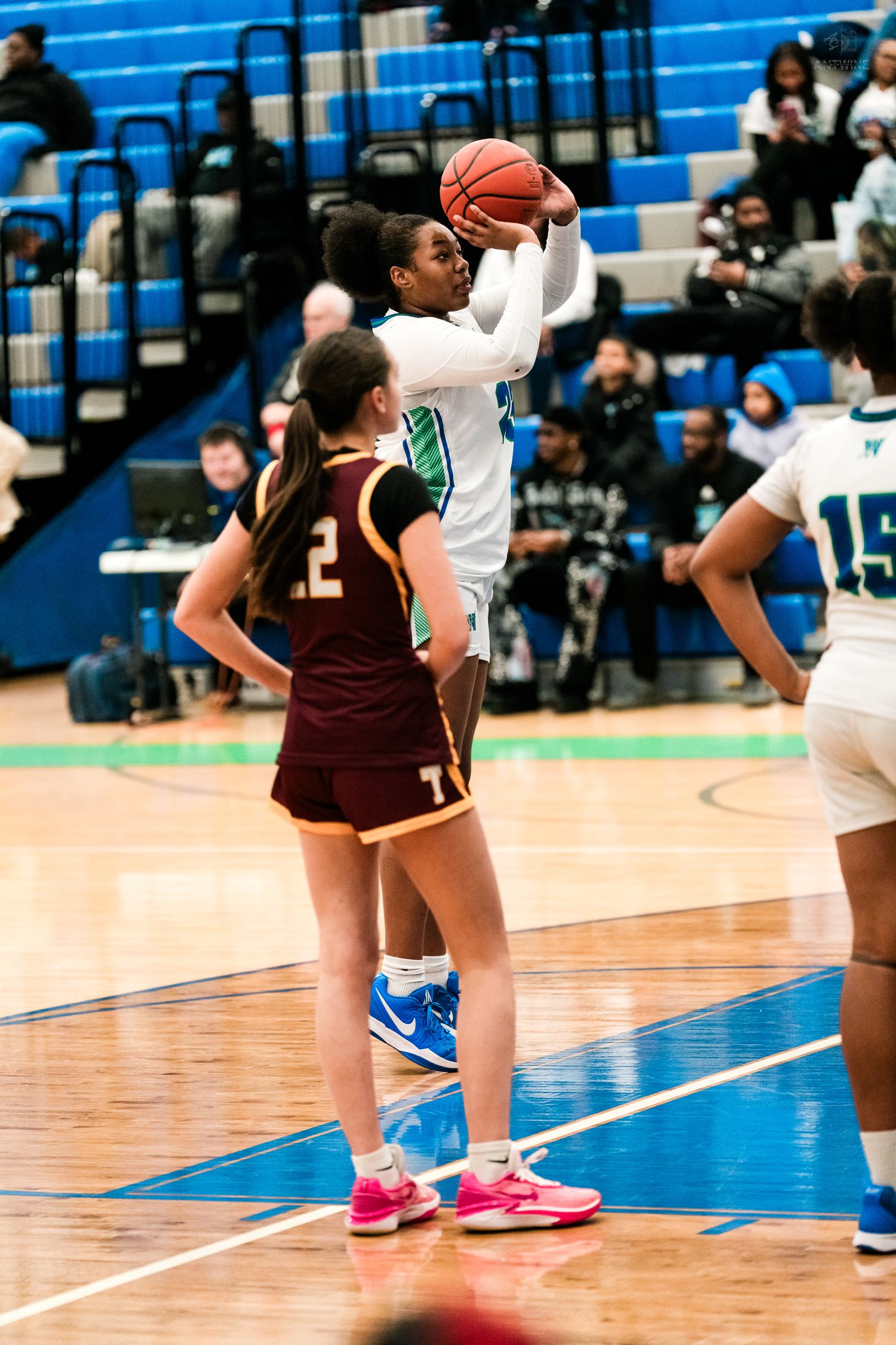 Warriors player #23 shoots a jump shot over Turpin defender during girls high school basketball.