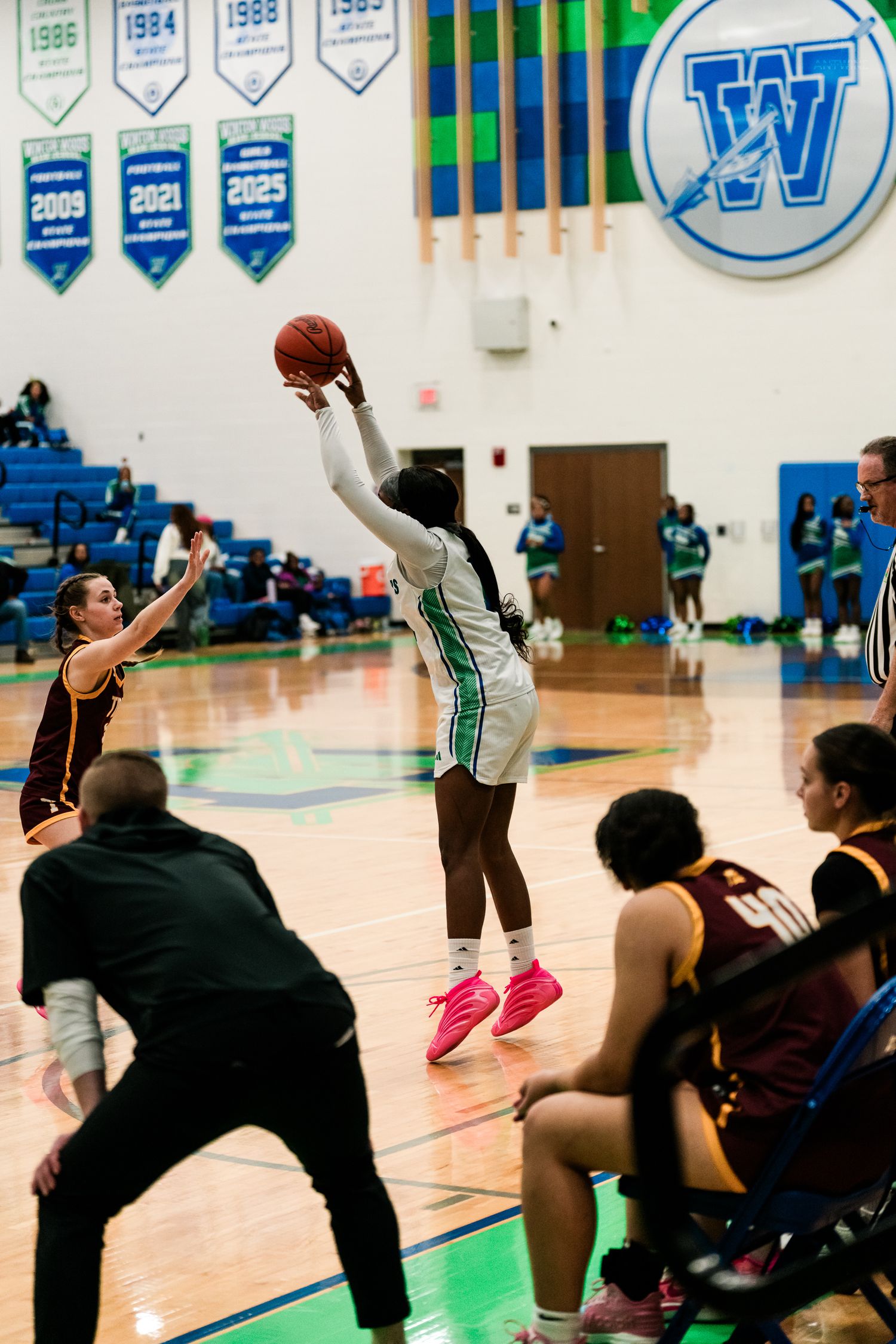 Winton Woods girls basketball player shoots a jump shot over a Turpin defender near the sideline.