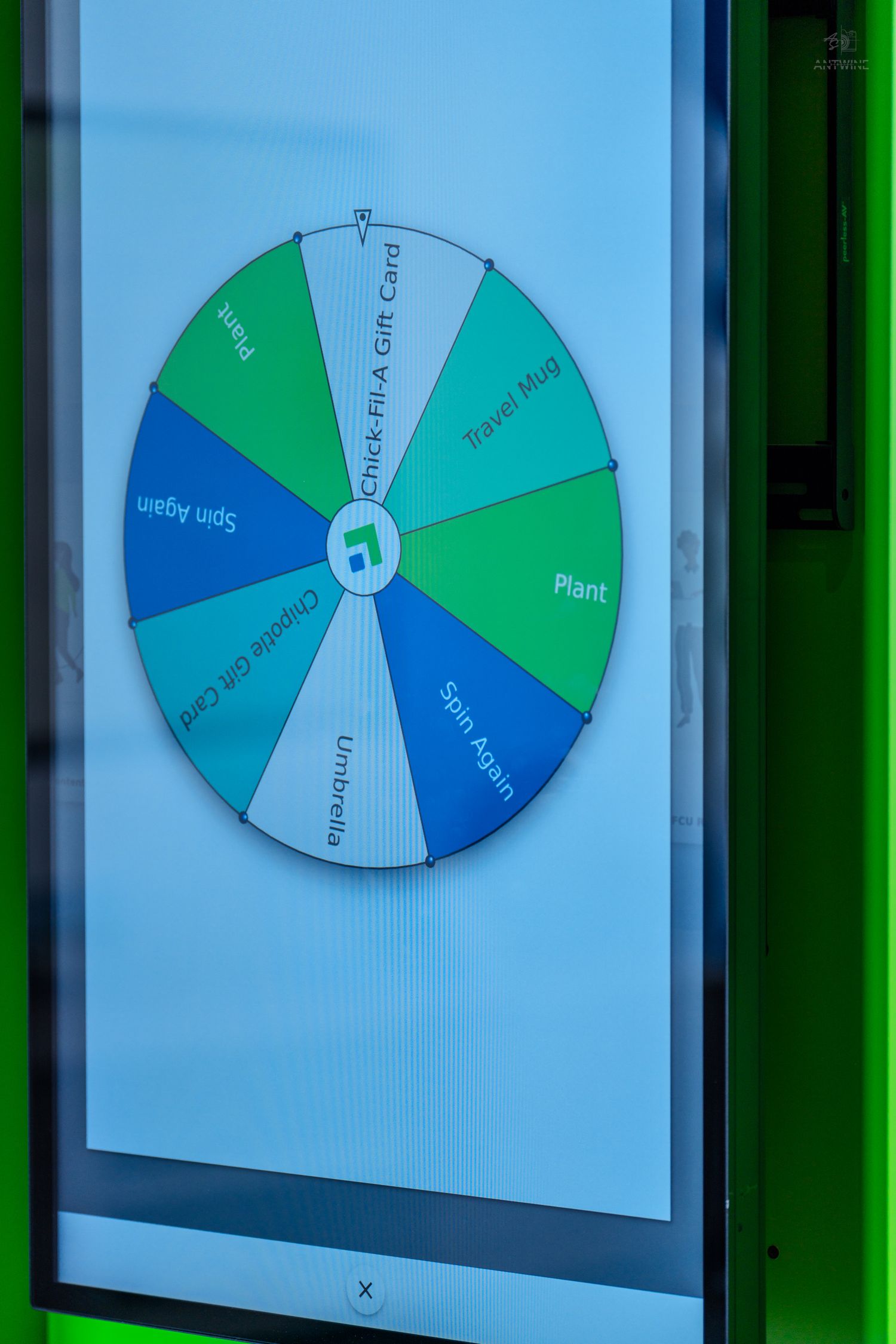 A colorful digital prize wheel spinner displaying segments including Chick-Fil-A Gift Card, Travel Mug, Plant, and Spin Again.