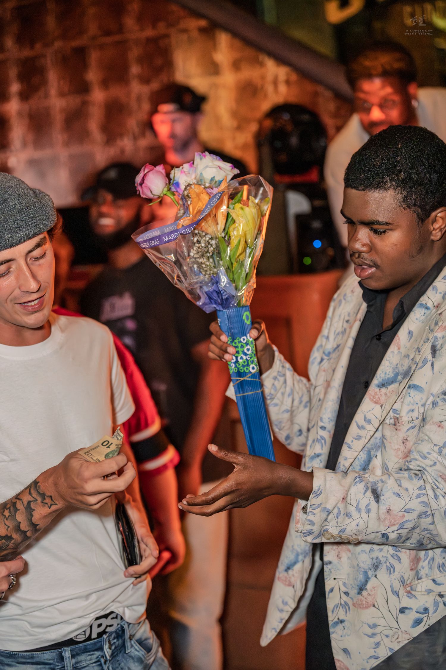 Two men exchanging money for a bouquet of flowers at a vibrant nightclub event.