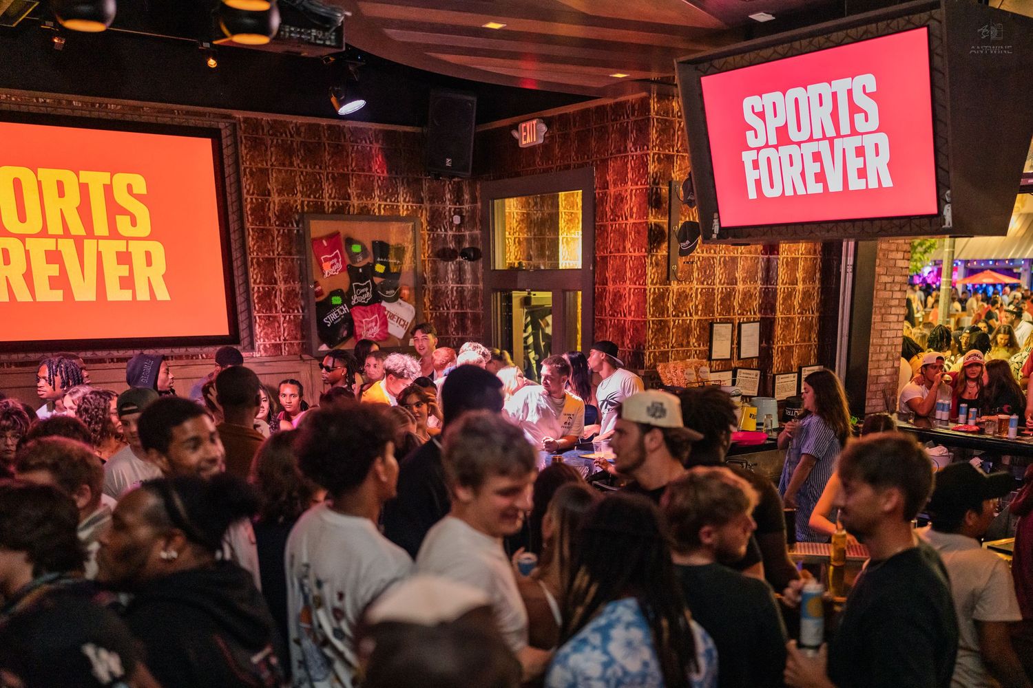 Busy sports bar crowd watching ESPN on large screens during an exciting live event.