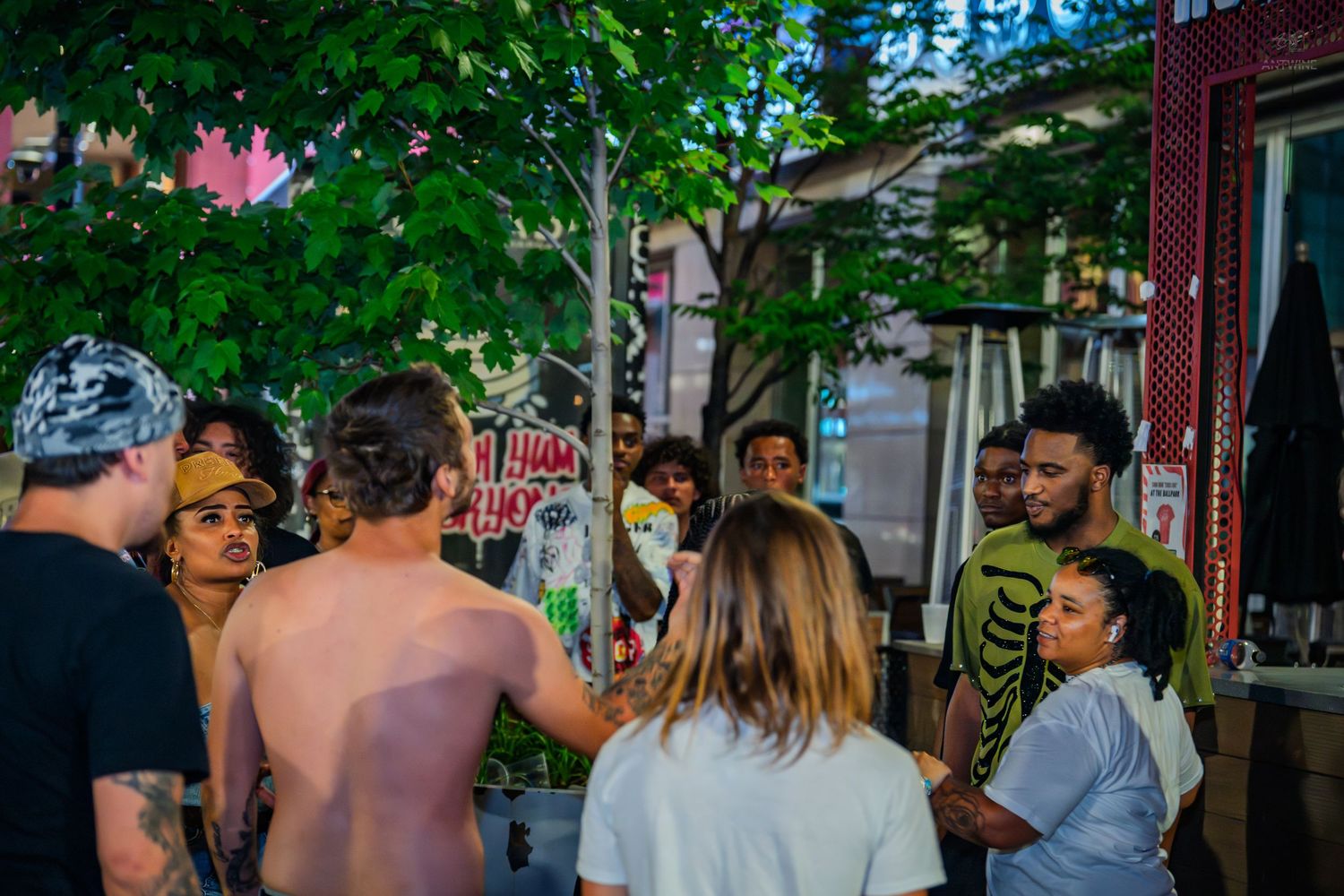 Diverse group of friends gathered outdoors at urban nighttime event.
