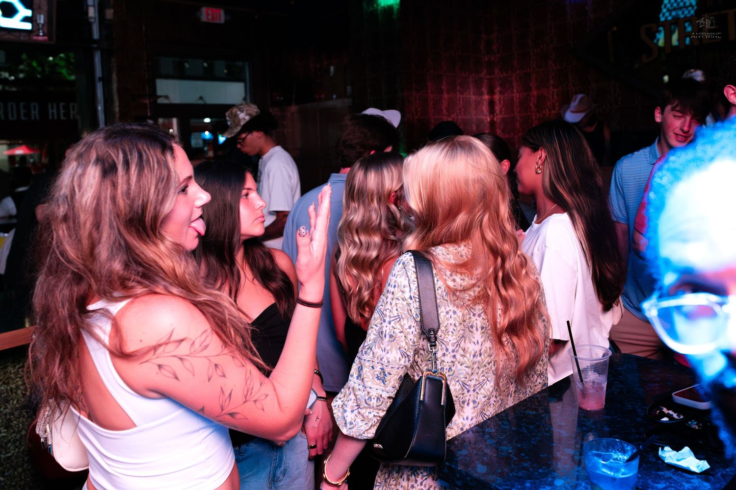 Group of young women dancing and socializing at a nightclub.