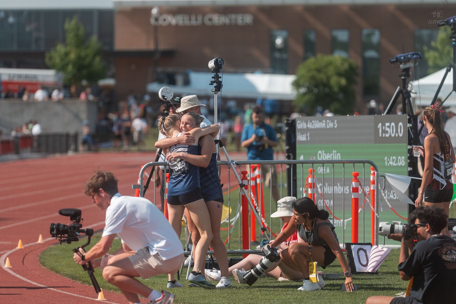 Two athletes embrace near the finish line at a track meet outside the Lovelli Center.