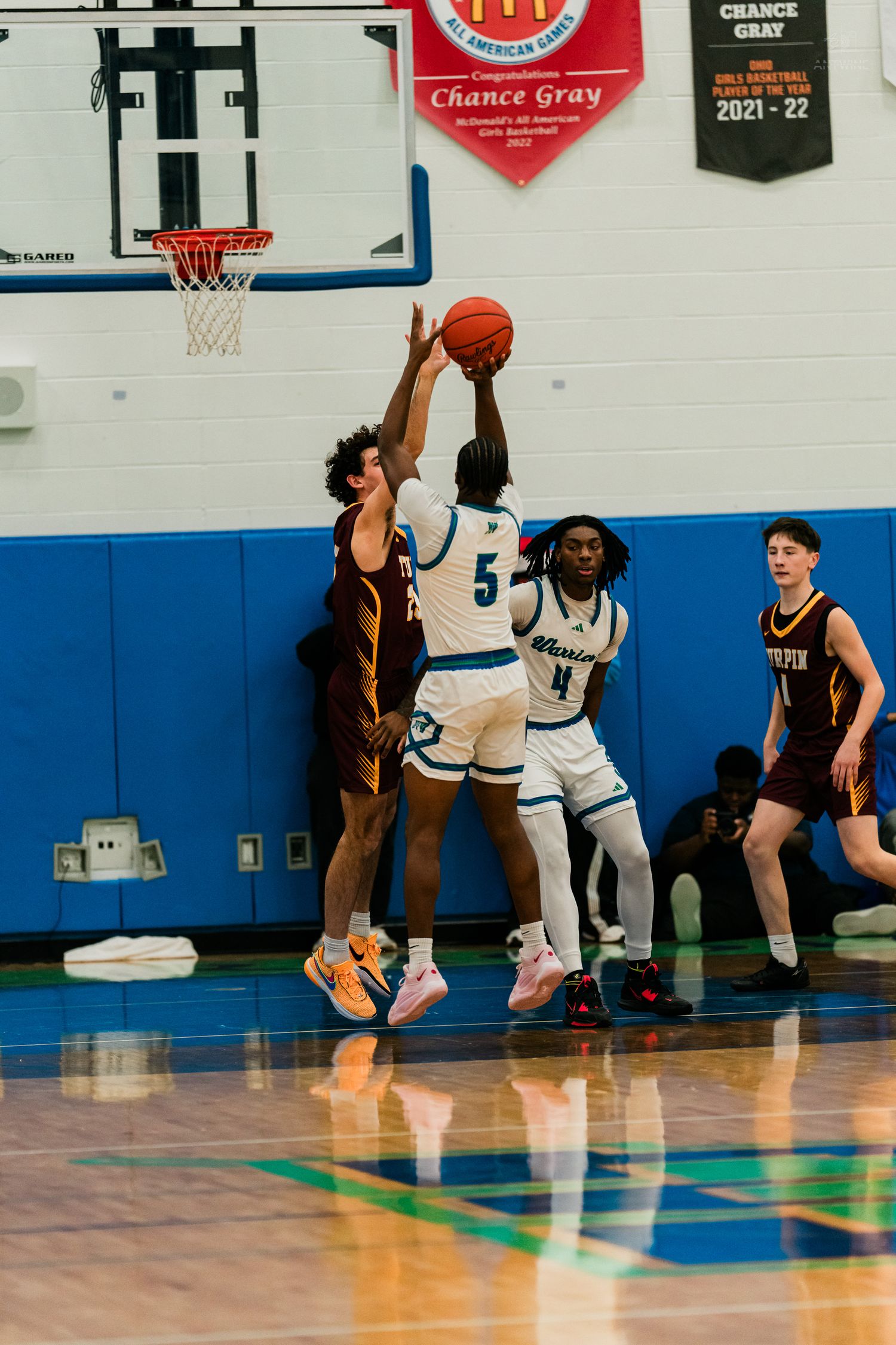 Player #5 blocks a shot attempt near the basket during a competitive high school basketball game at Winton Woods.