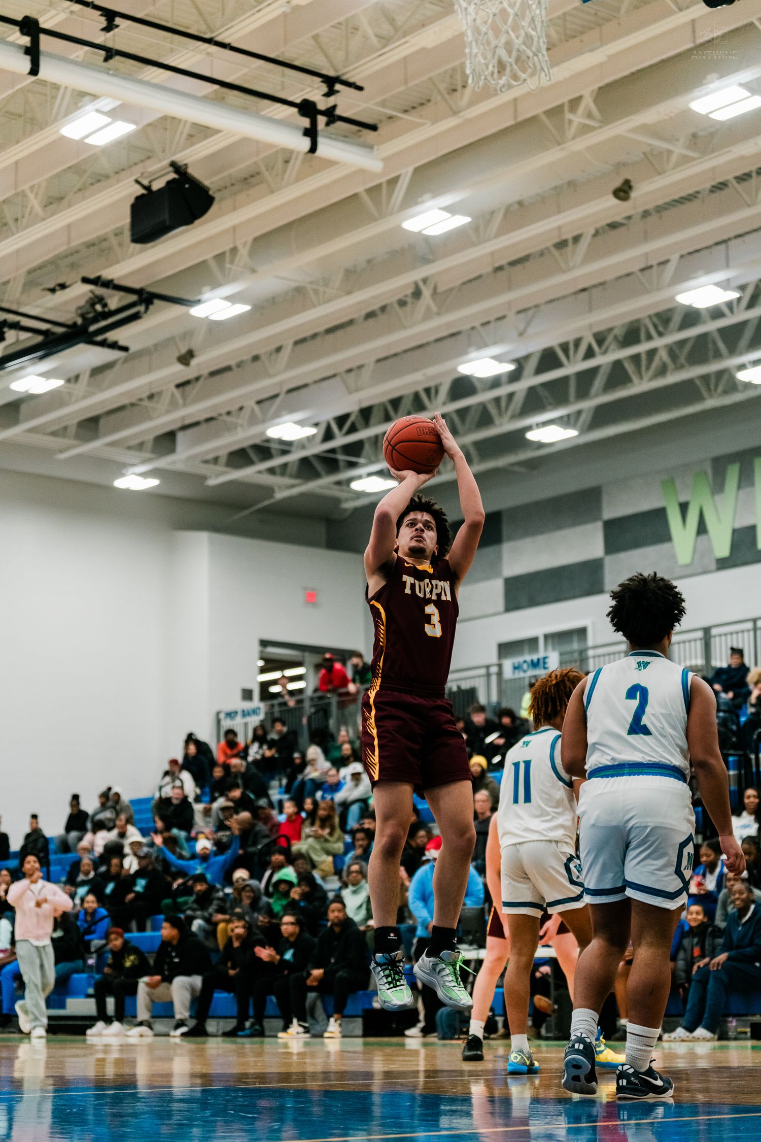 Turpin player #3 shoots jump shot during high school basketball game before packed crowd in gymnasium.