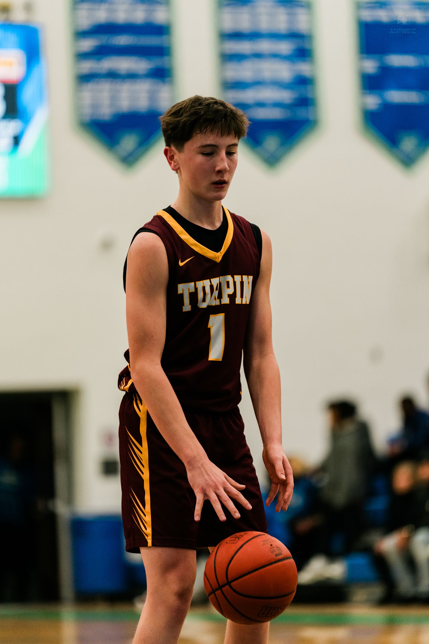 Turpin High School basketball player number 1 dribbles the ball during an indoor game.