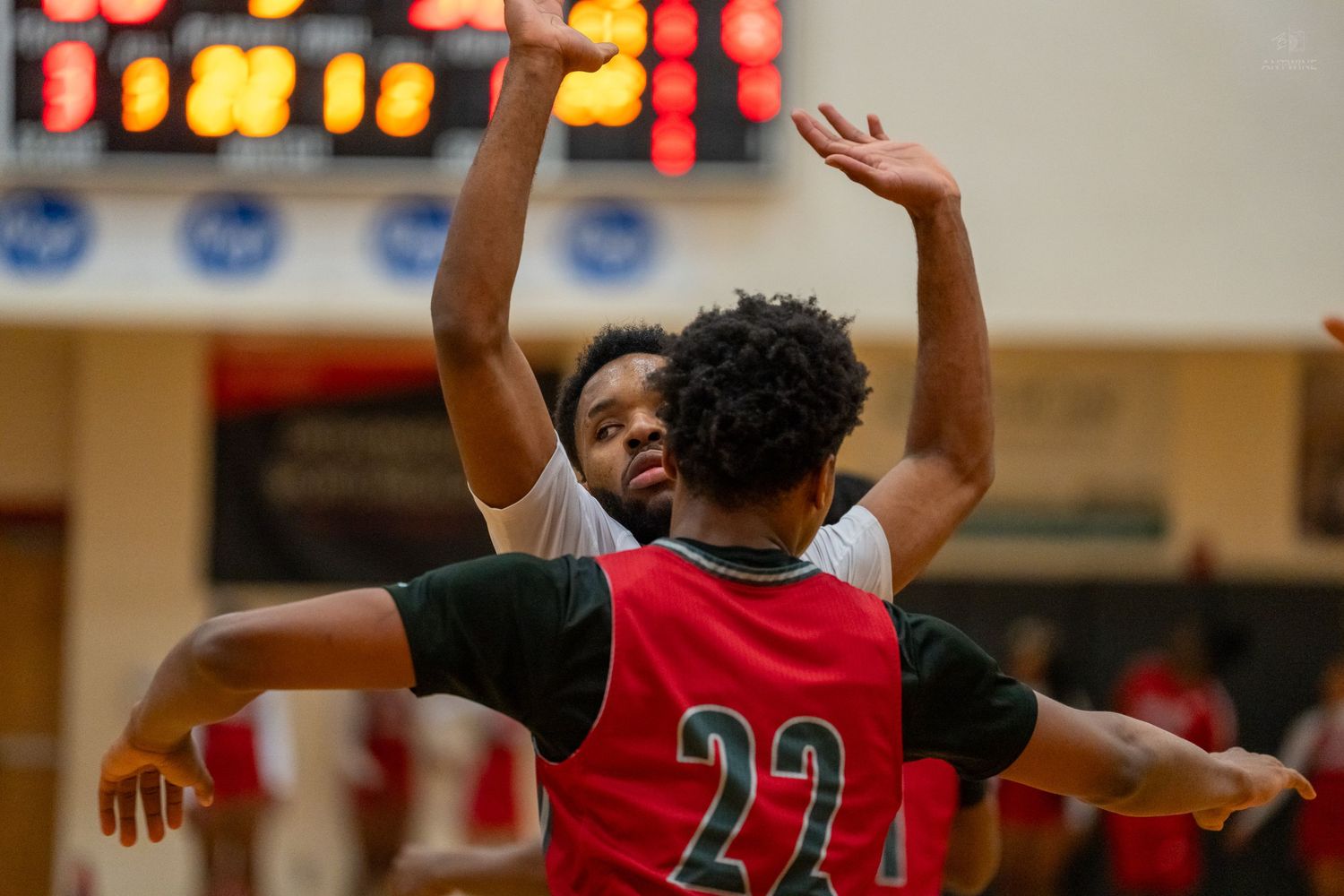 Two high school basketball players battle for position under the basket during an intense game.