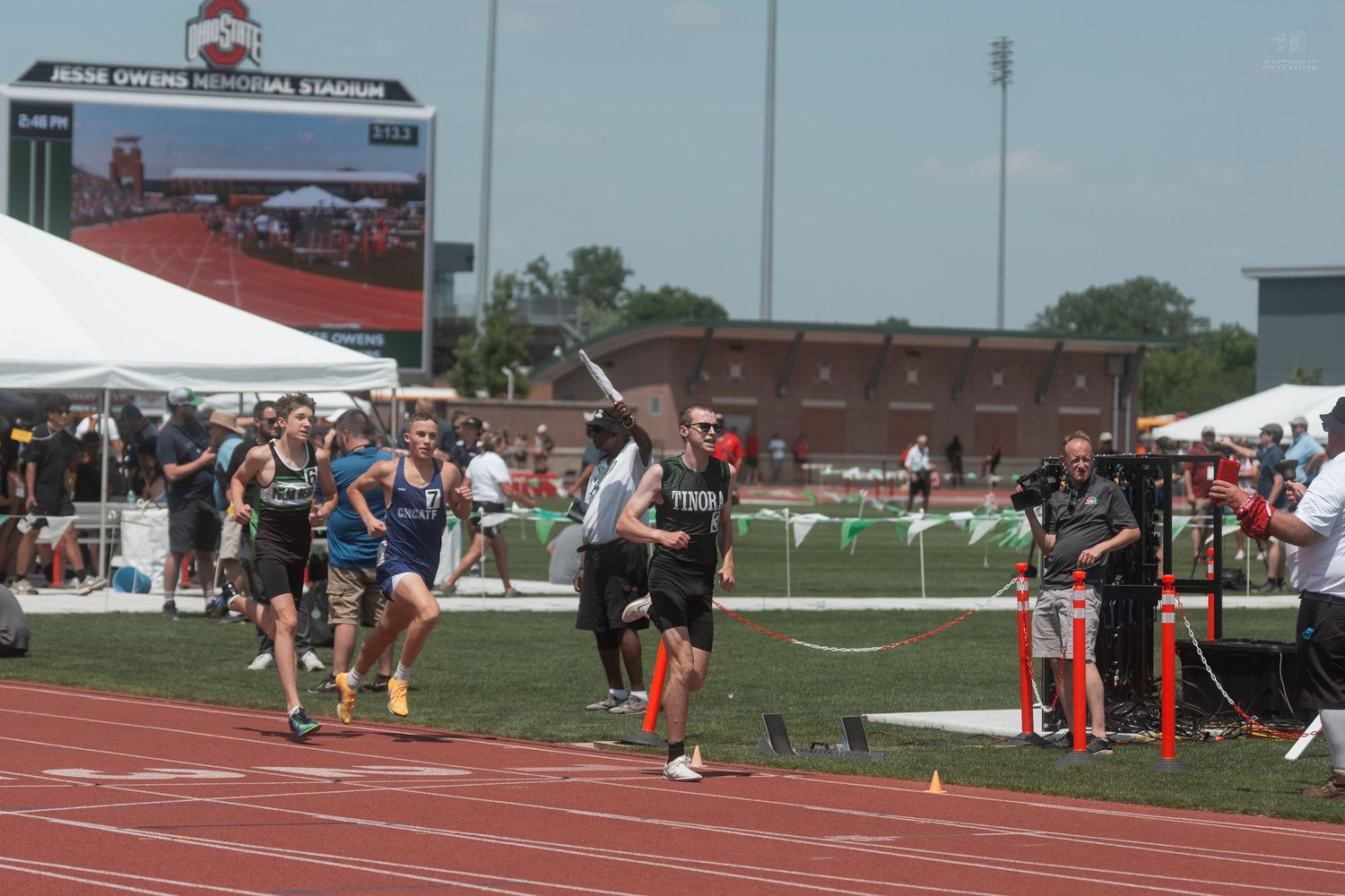 Athletes sprint toward the finish line at Jesse Owens Memorial Stadium during a track and field meet.