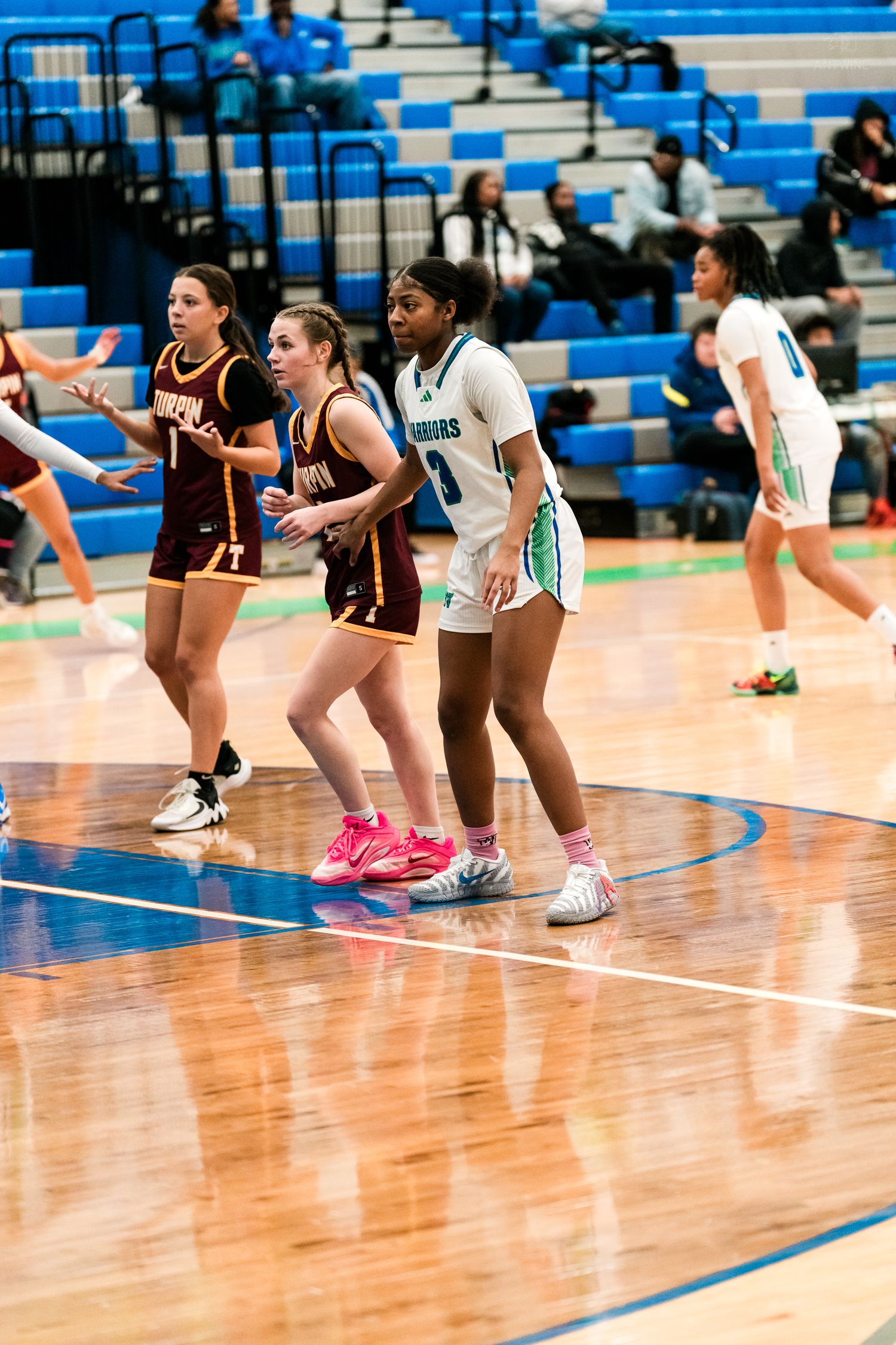 Female basketball players in white Harbors and maroon Turpin uniforms compete during high school game.