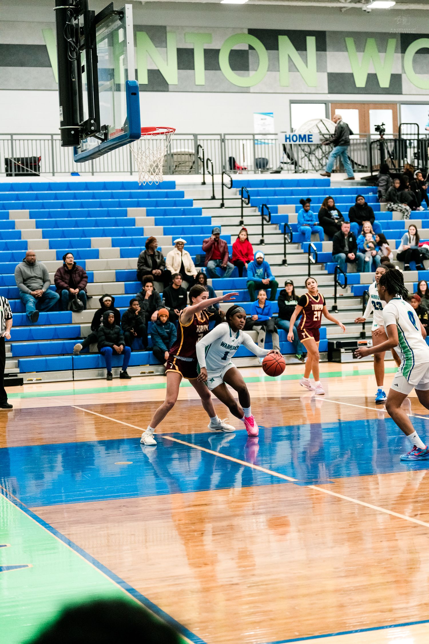 Winton Woods girls basketball player drives past a Turpin defender toward the basket.