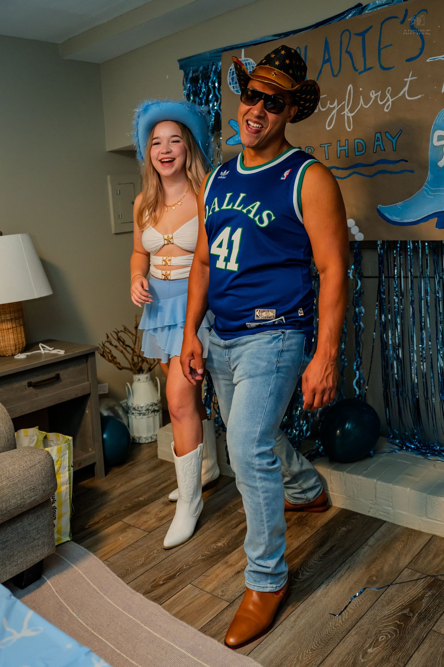 Smiling couple posing at a blue and white 21st birthday party with balloon decorations.