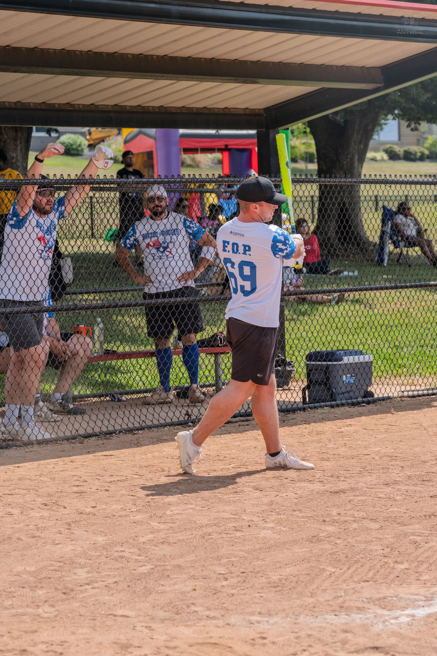 Softball batter in EOP jersey number 69 preparing to swing during a sunny outdoor charity game.
