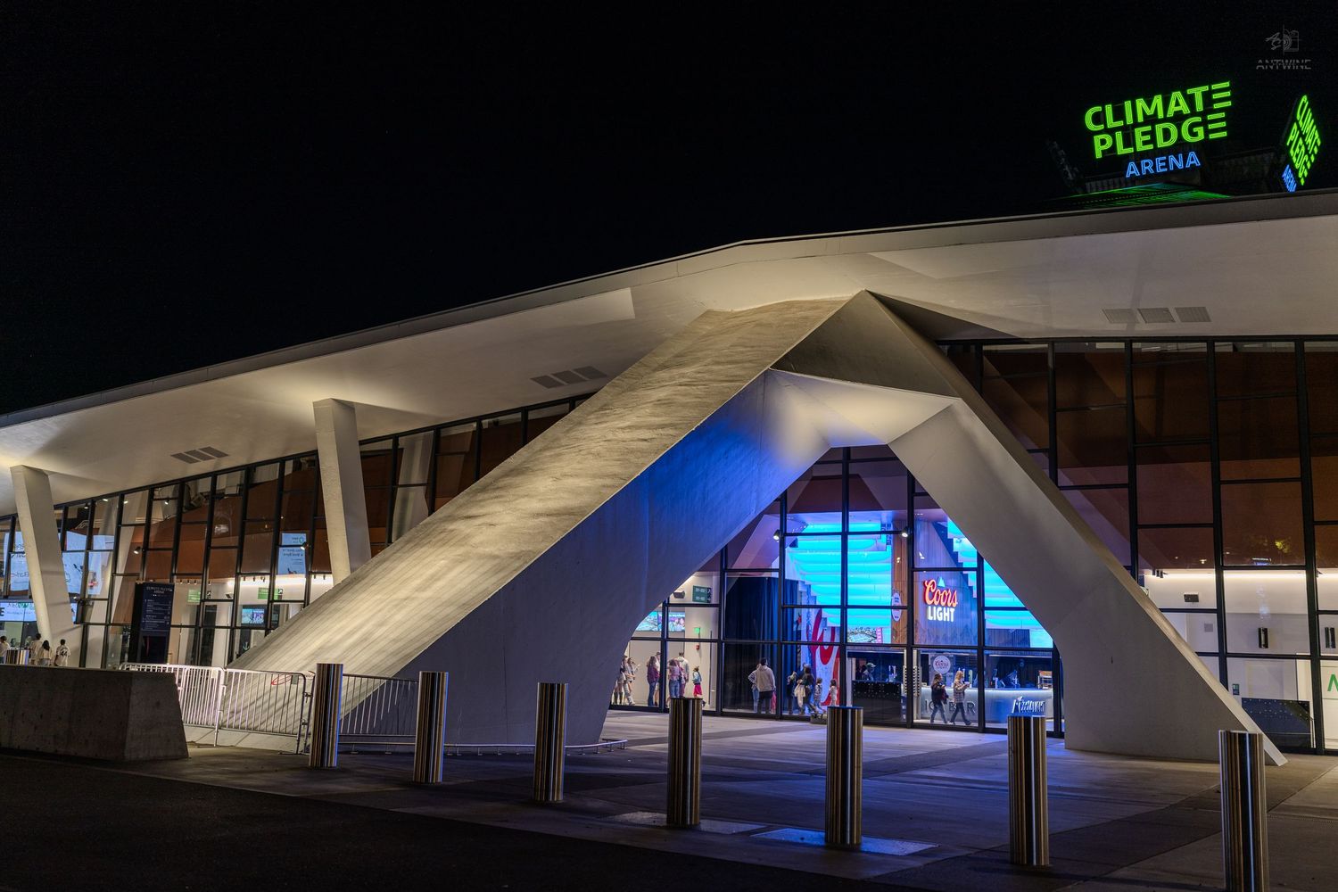 Climate Pledge Arena exterior lit up at night with modern angular architecture in Seattle, Washington.