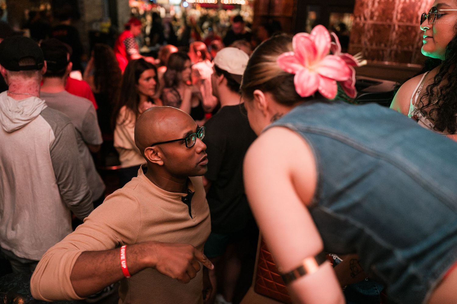 Man and woman dancing together at a vibrant crowded nightclub party event.