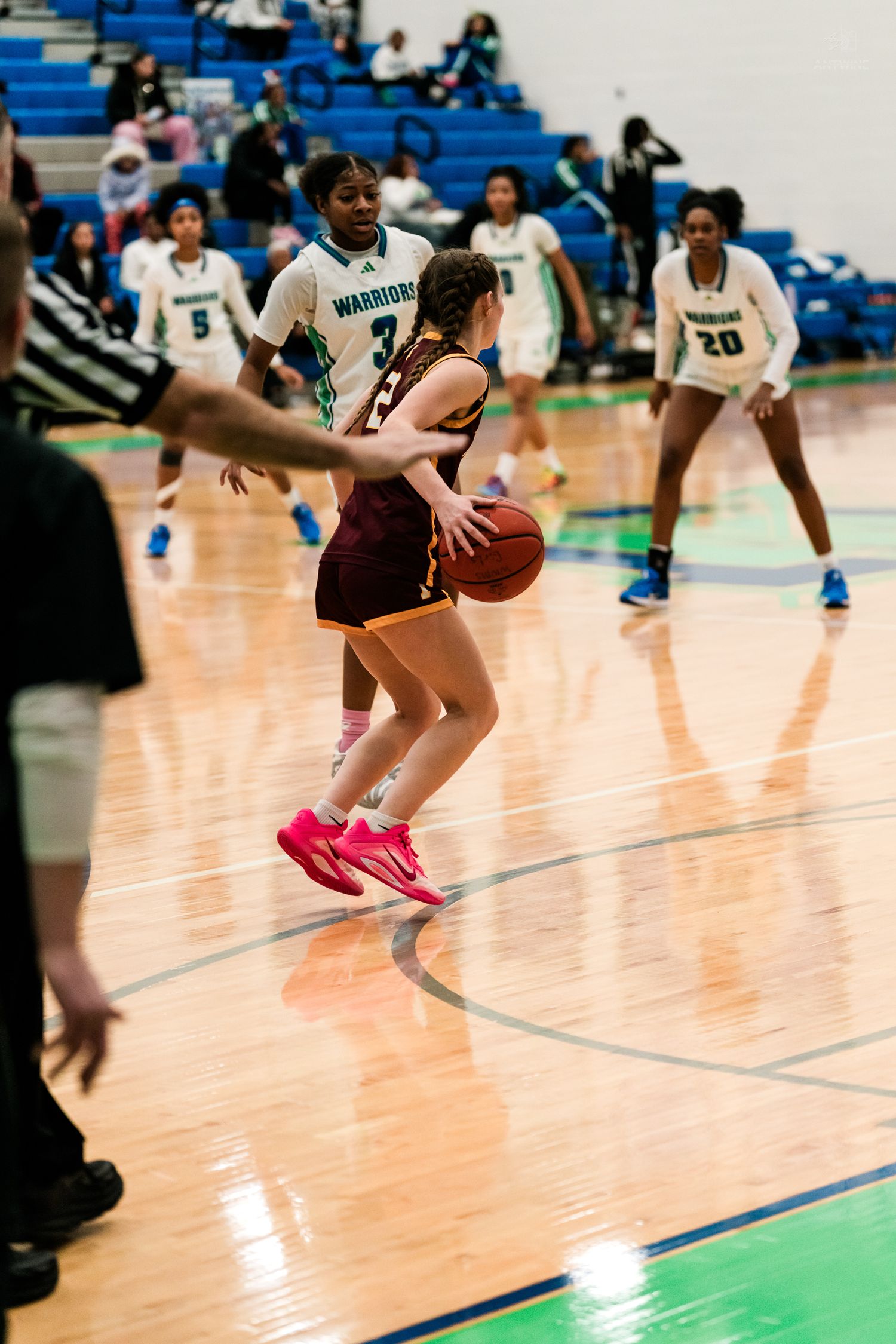 Turpin player in maroon handles ball while Warriors defenders in teal apply pressure during girls basketball game.